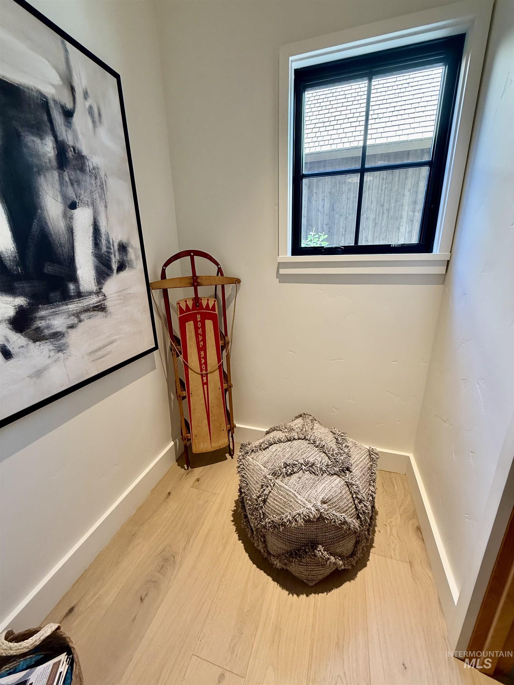 Living area with wood finished floors and baseboards