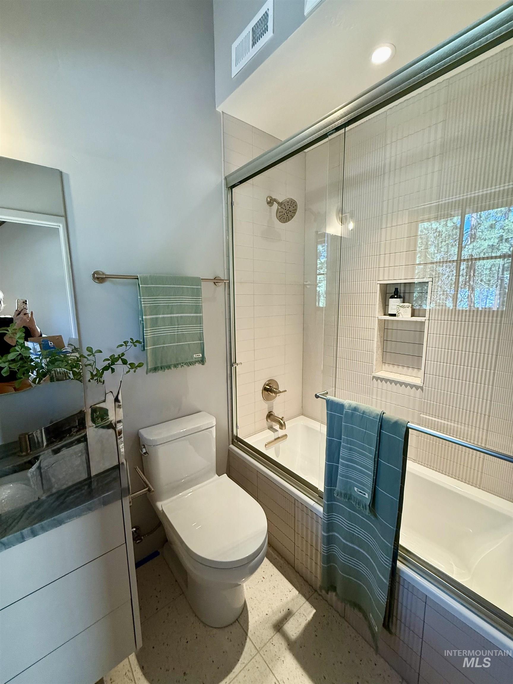 Bathroom with tiled shower / bath and toilet