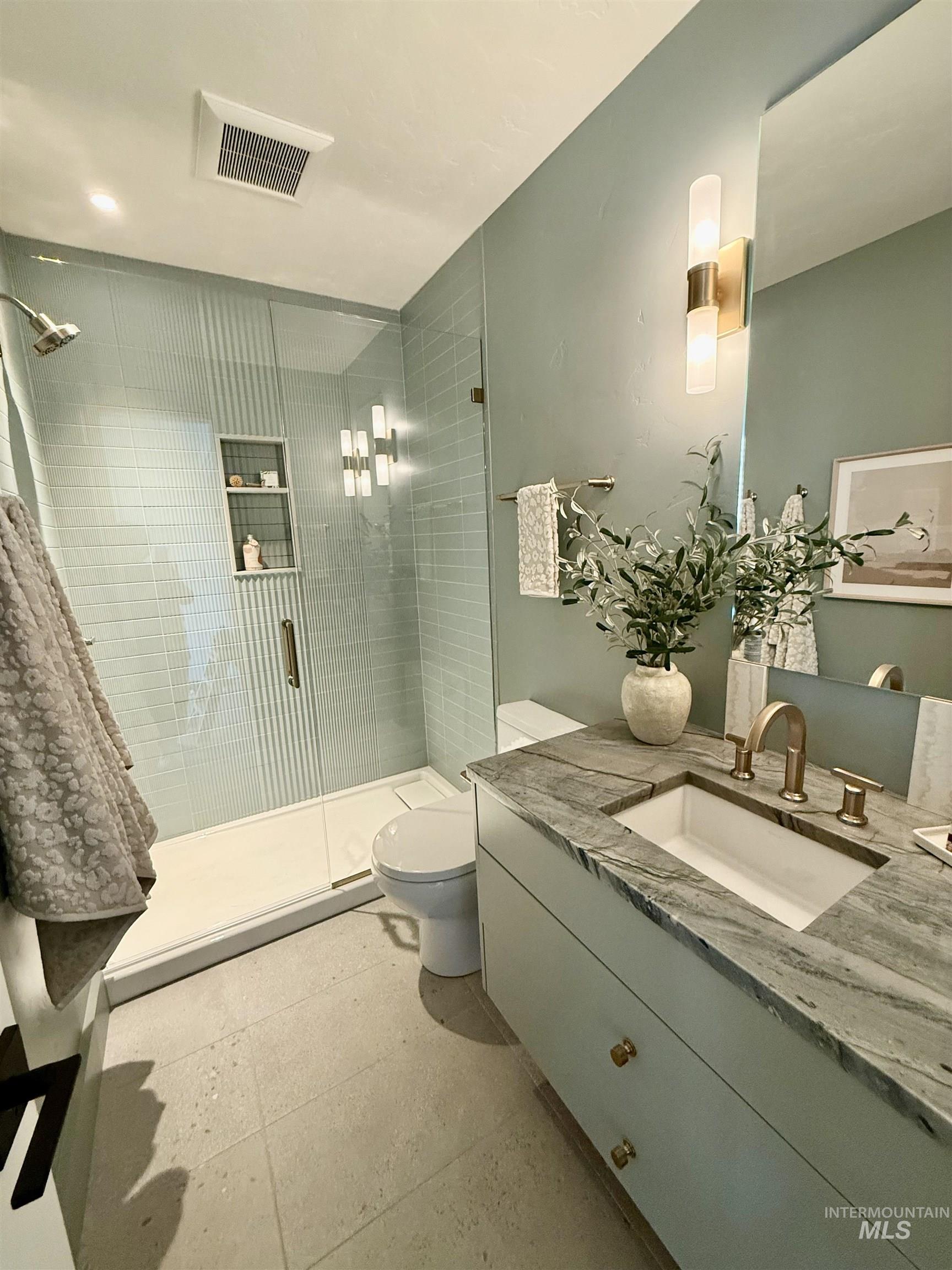 Full bath featuring a shower stall and vanity