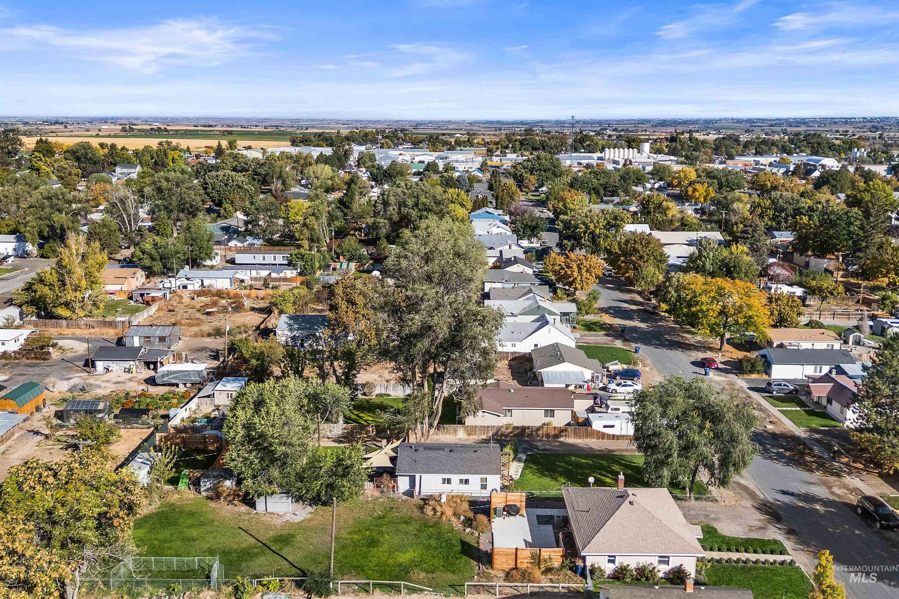 Aerial view of property and surrounding area featuring nearby suburban area
