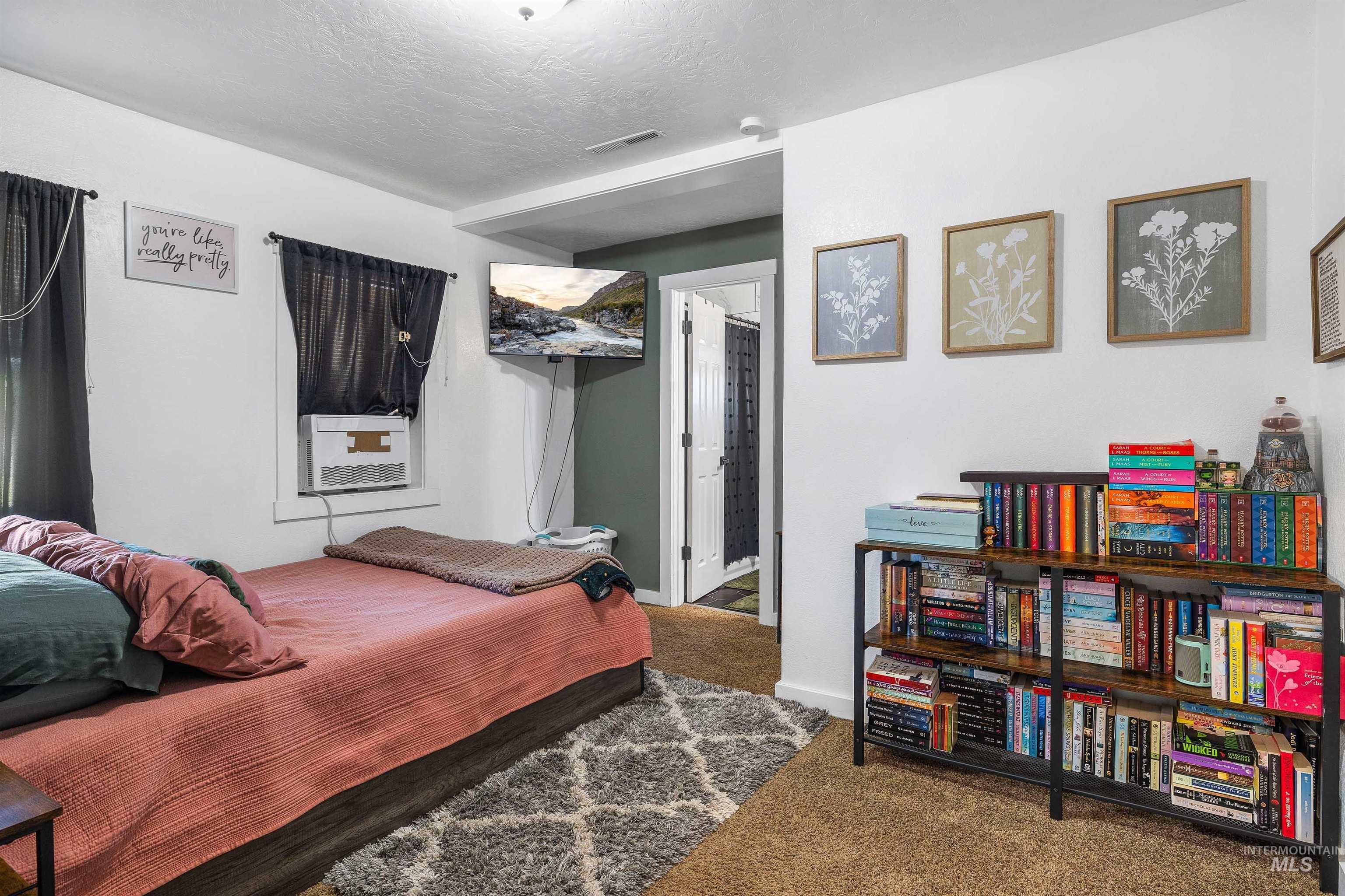 Carpeted bedroom featuring baseboards and a textured ceiling