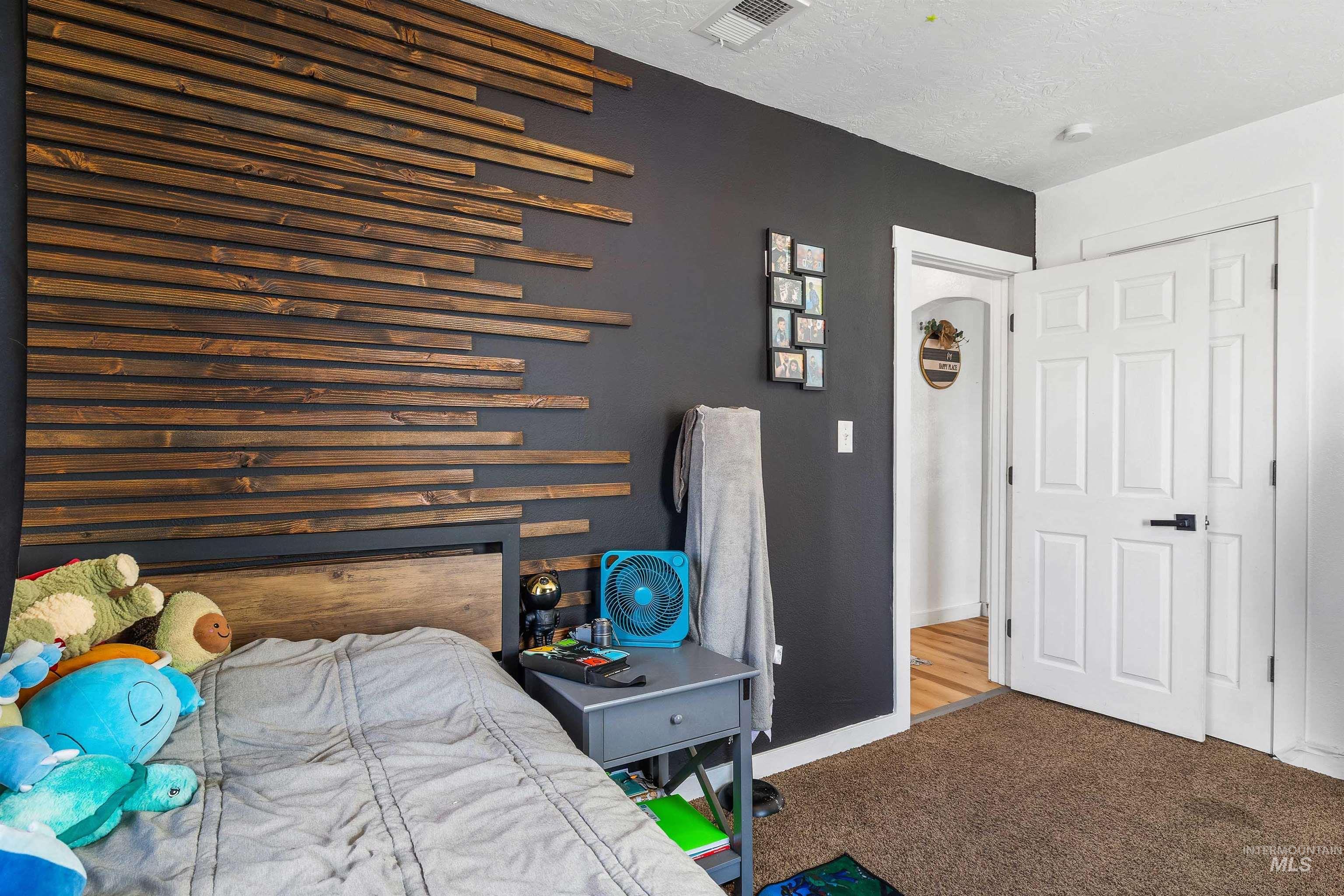 Carpeted bedroom with a textured ceiling and baseboards