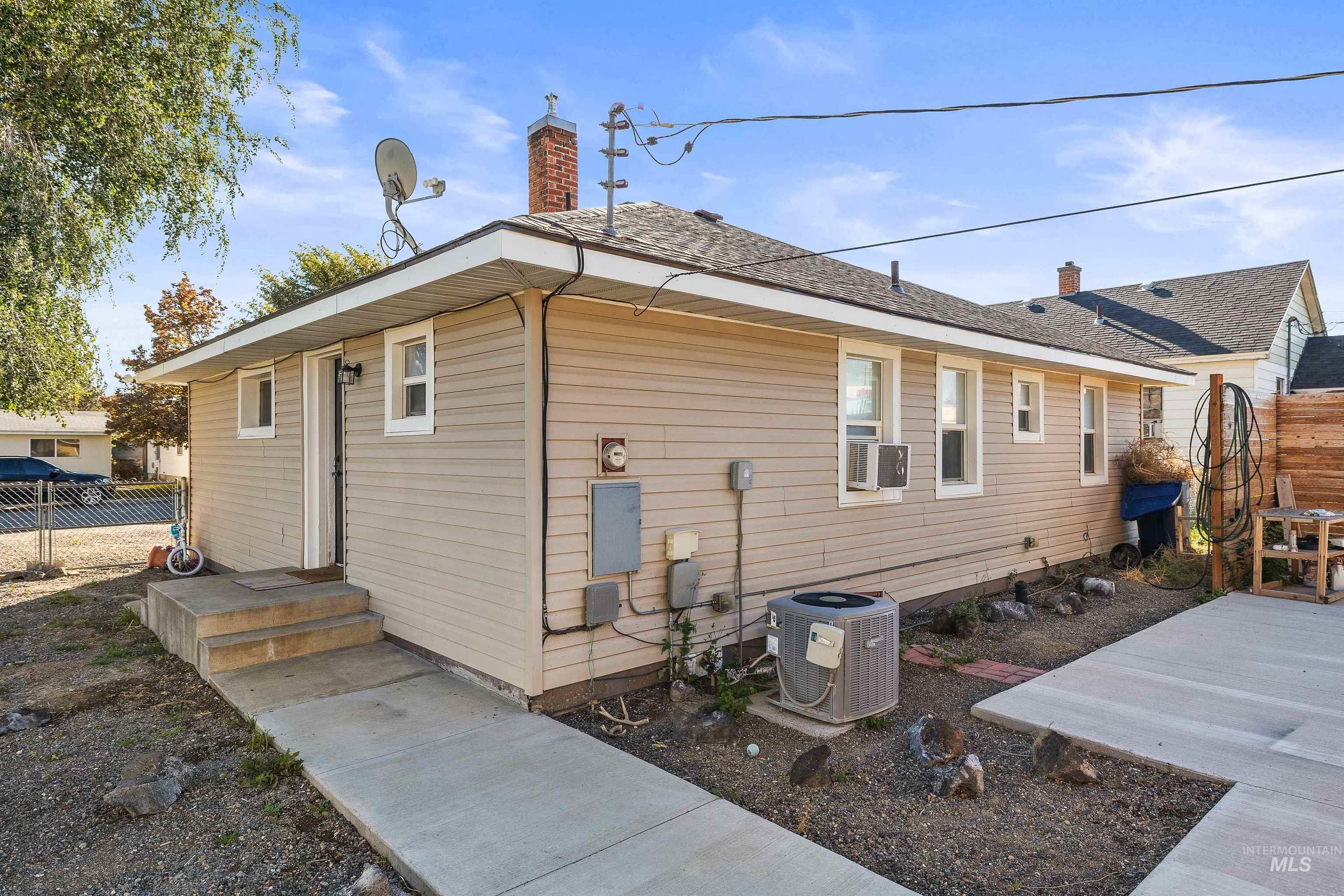 View of home's exterior with a central AC unit and a chimney