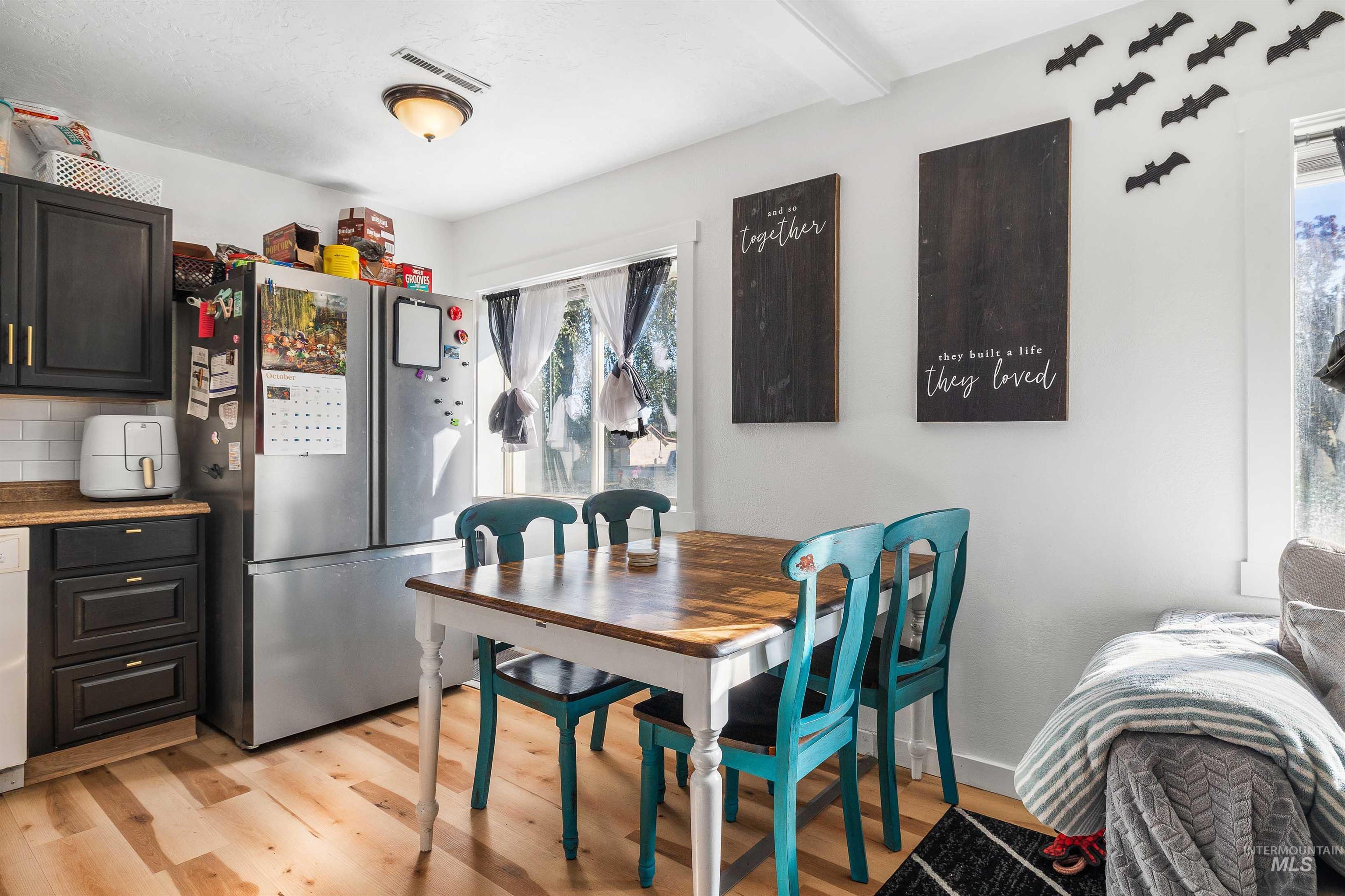Dining space with healthy amount of natural light and light wood-style flooring