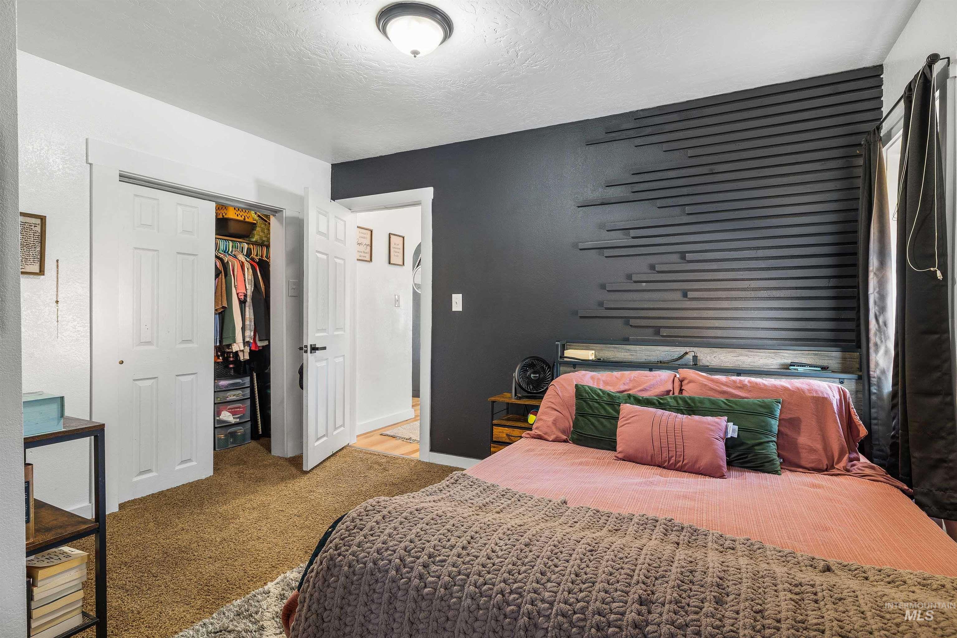 Bedroom featuring a closet, a textured ceiling, and light colored carpet