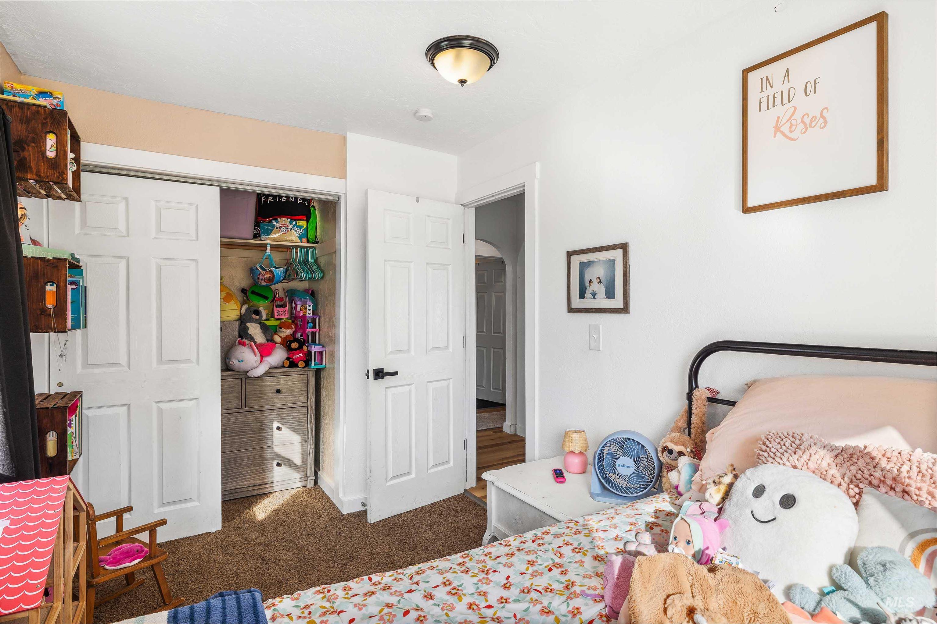 Bedroom featuring a closet, carpet, and arched walkways