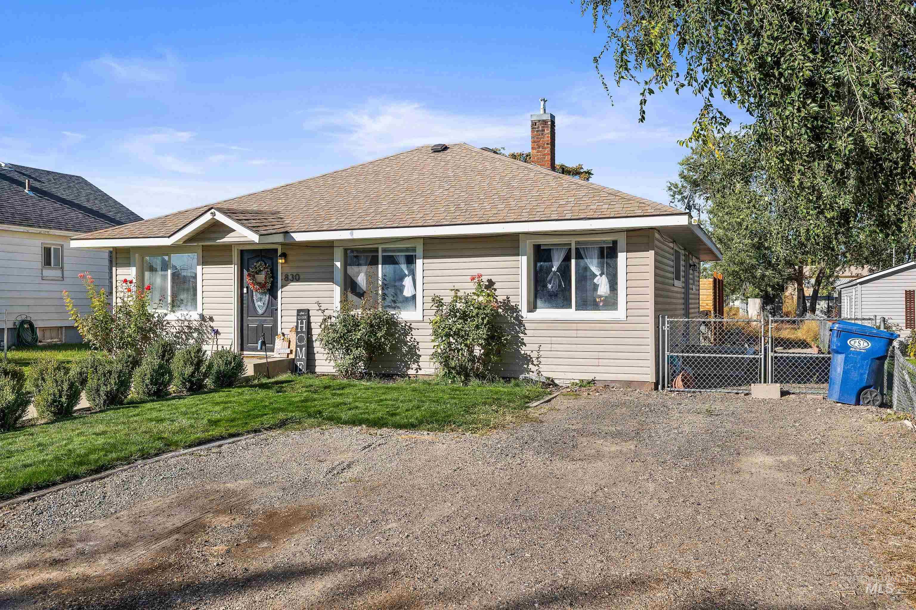 Rear view of property with roof with shingles, a chimney, and a gate