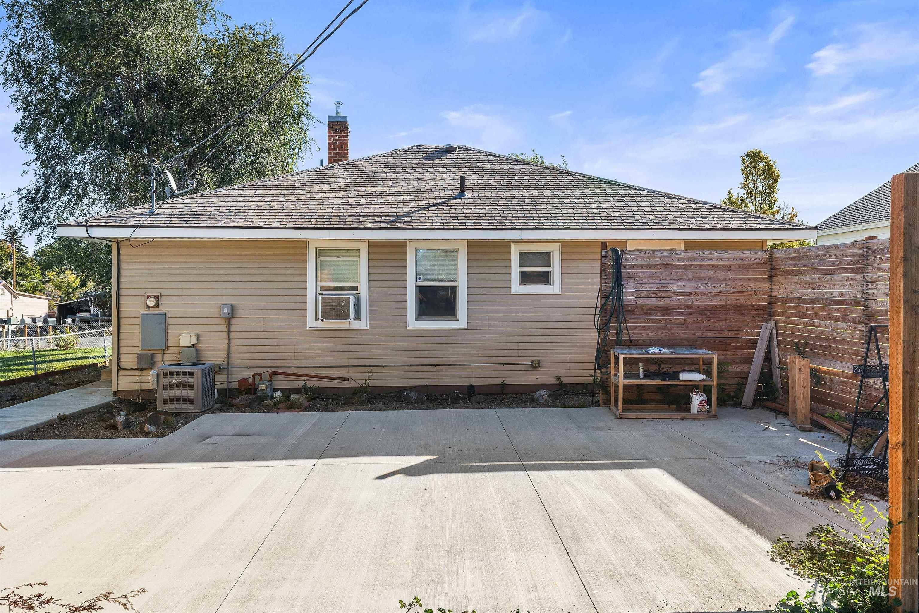Back of property with a chimney and a shingled roof