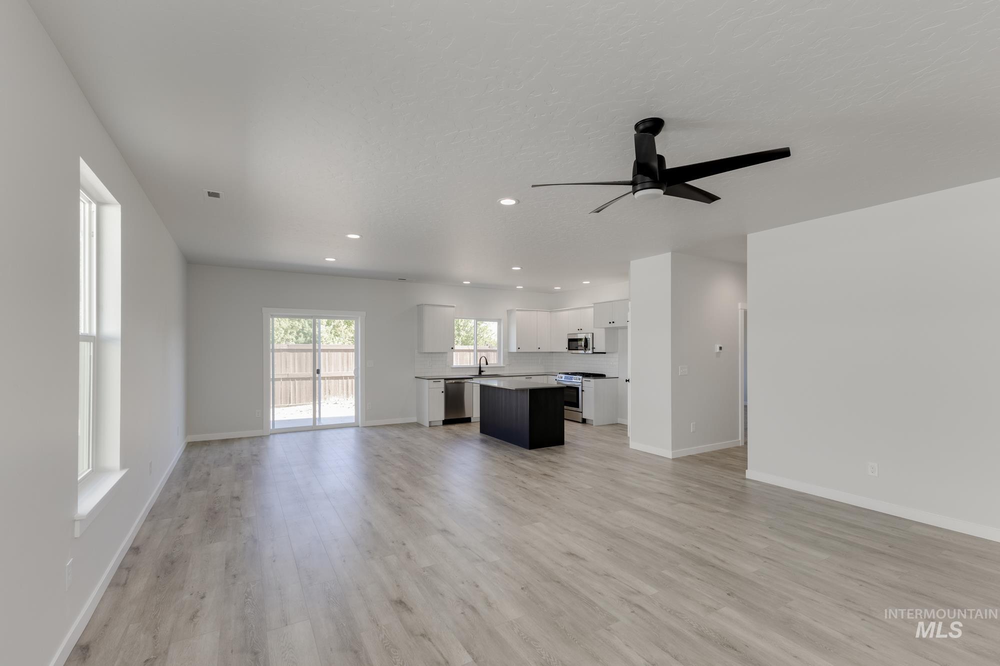 Unfurnished living room with light wood finished floors, recessed lighting, and a ceiling fan
