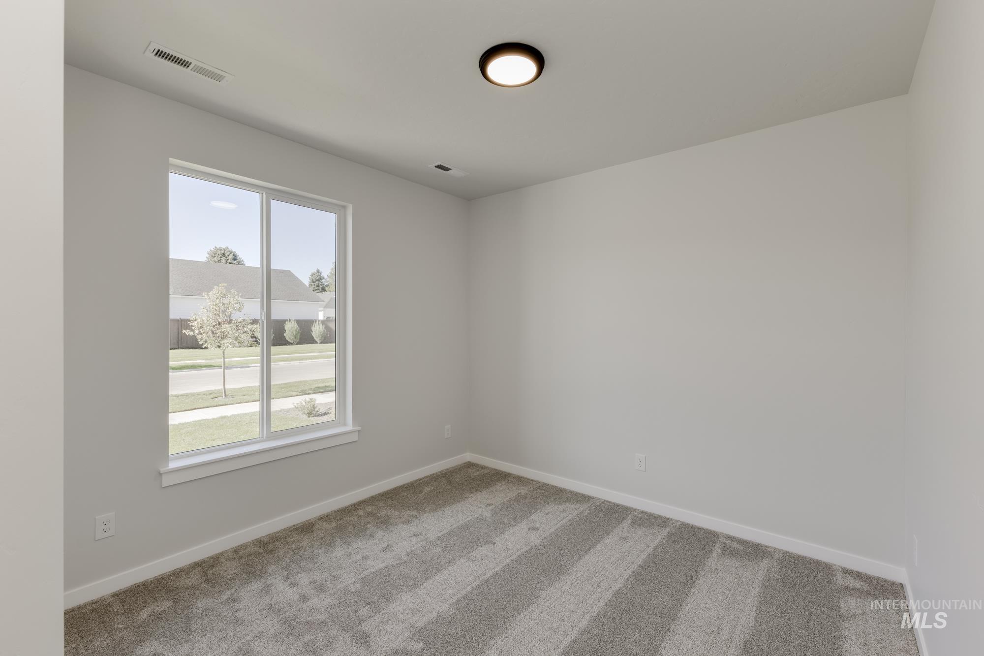Unfurnished room featuring light carpet and baseboards