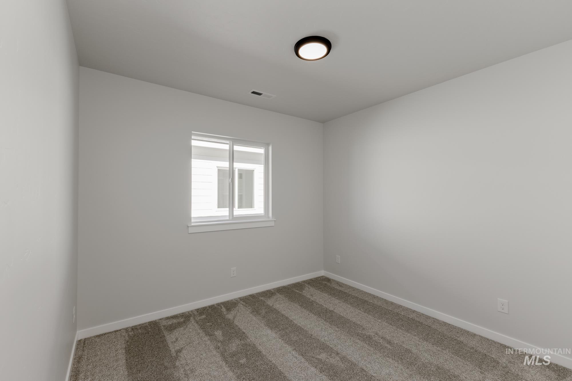 Carpeted empty room with baseboards