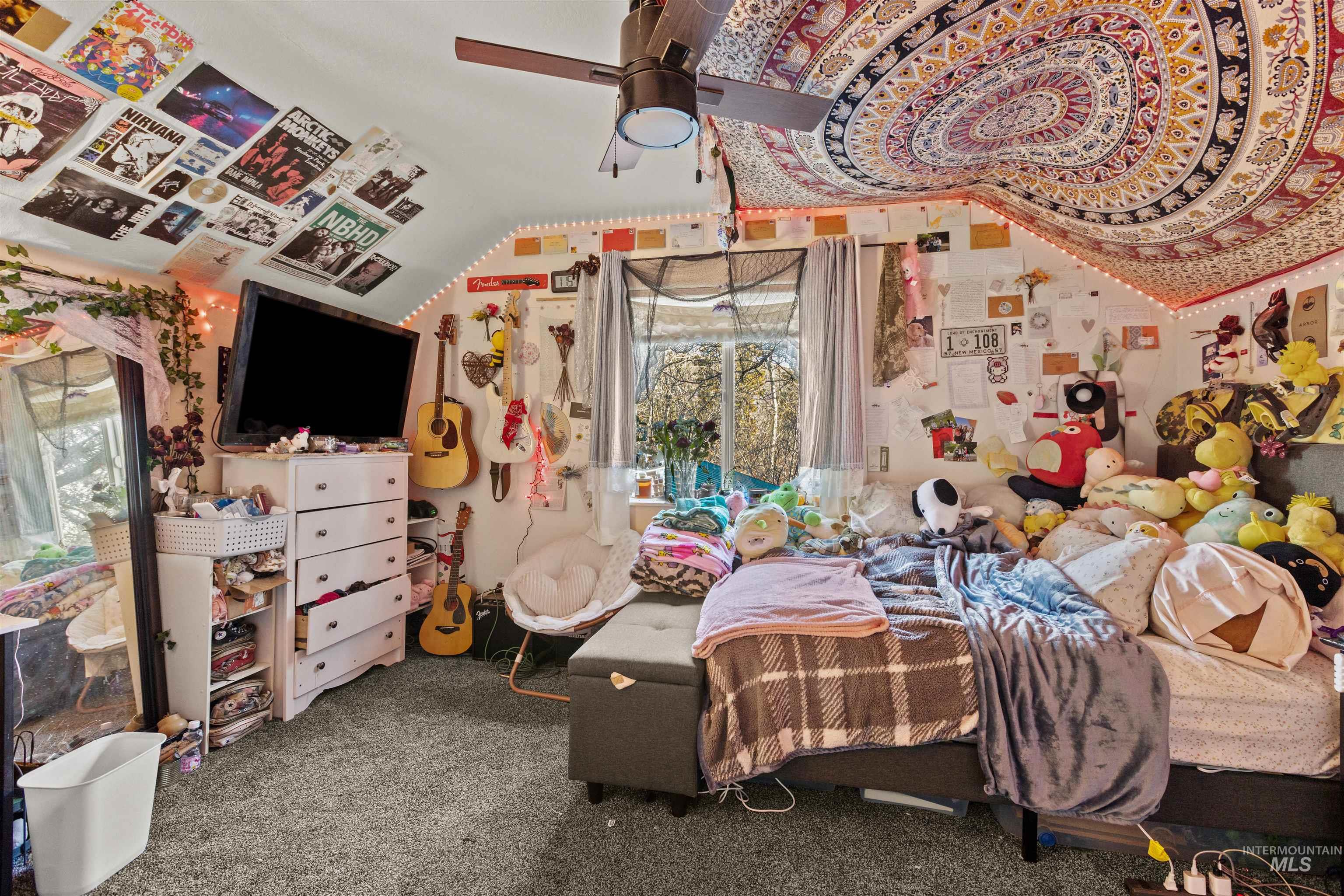 Carpeted bedroom with vaulted ceiling and a ceiling fan