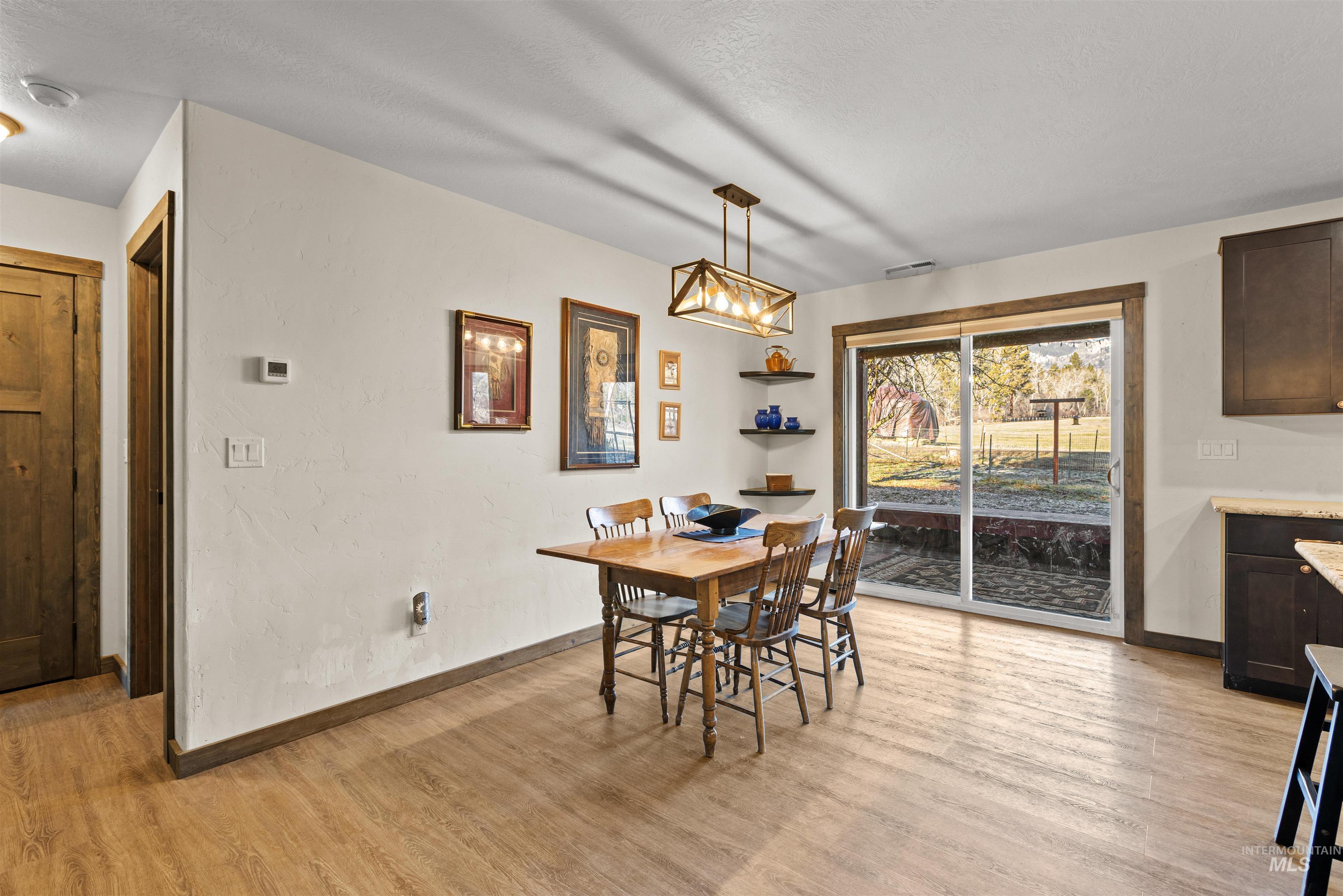 Dining area with light wood-style flooring and a textured wall