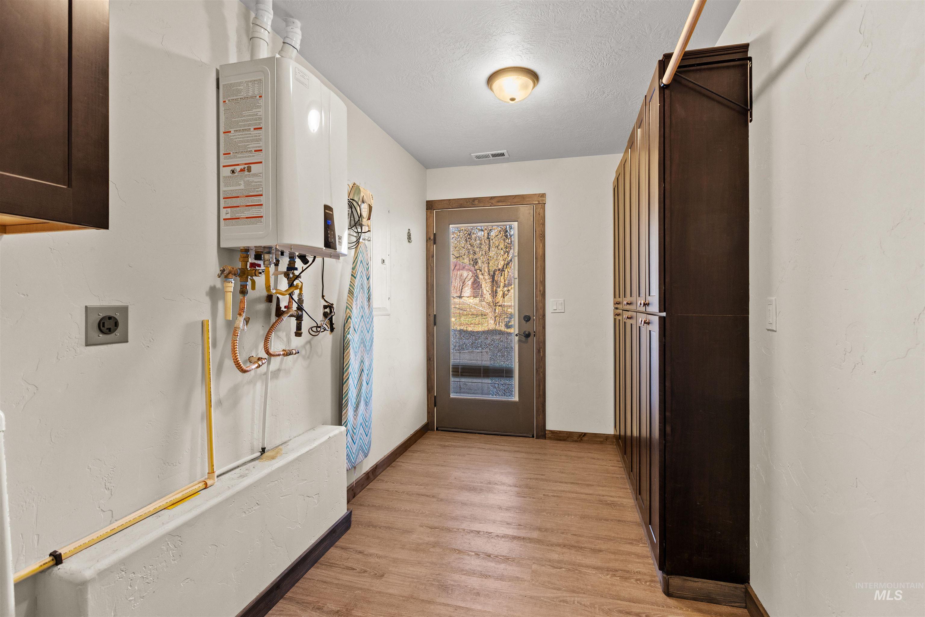 Hallway featuring a textured ceiling and wood finished floors