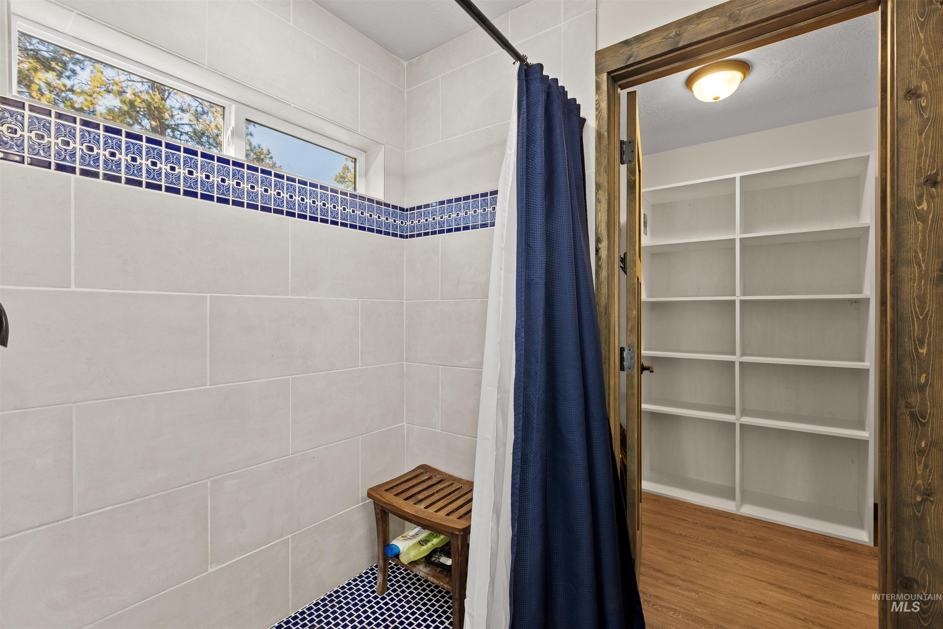 Bathroom featuring a shower stall and wood finished floors