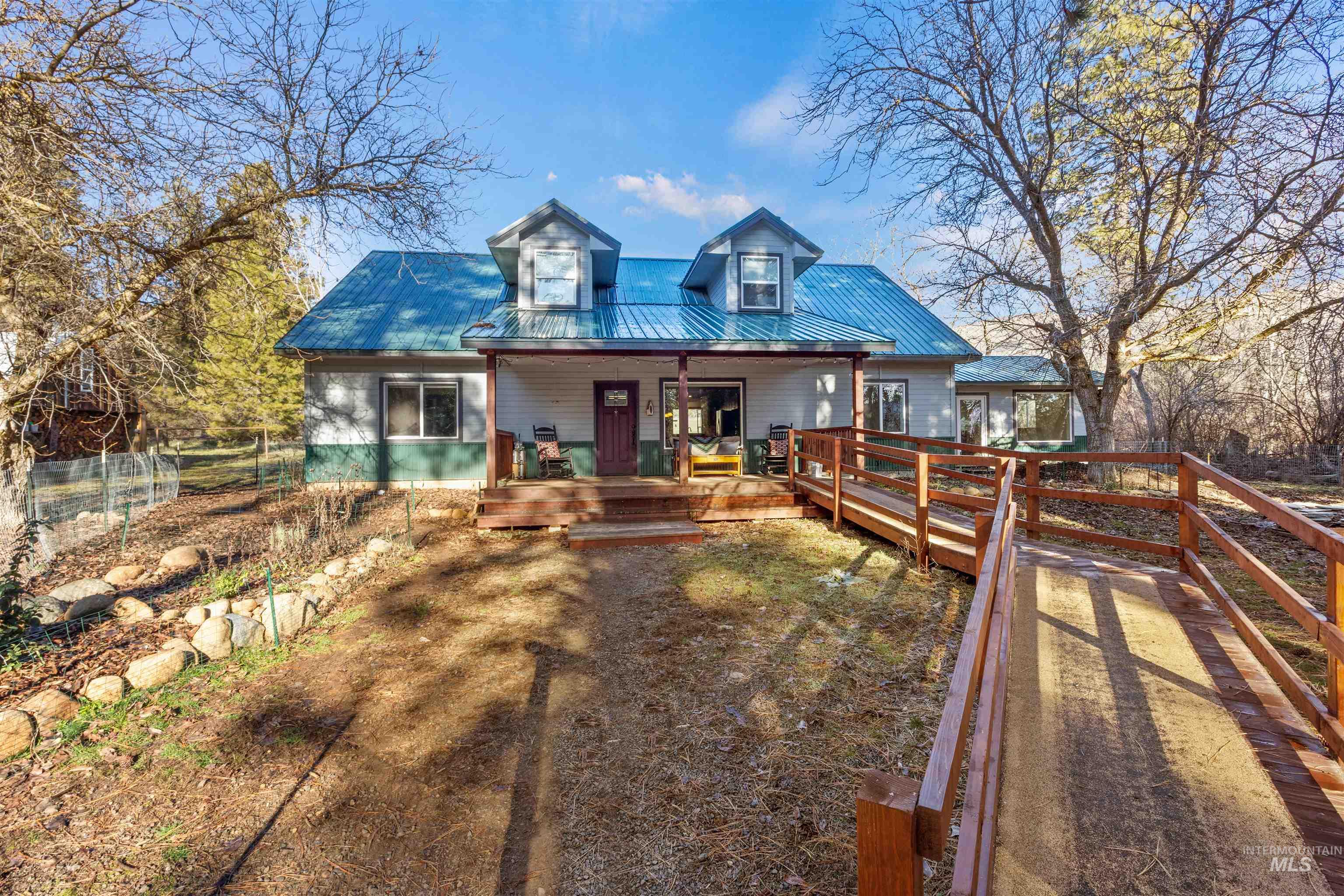 View of front of house with a metal roof and covered porch