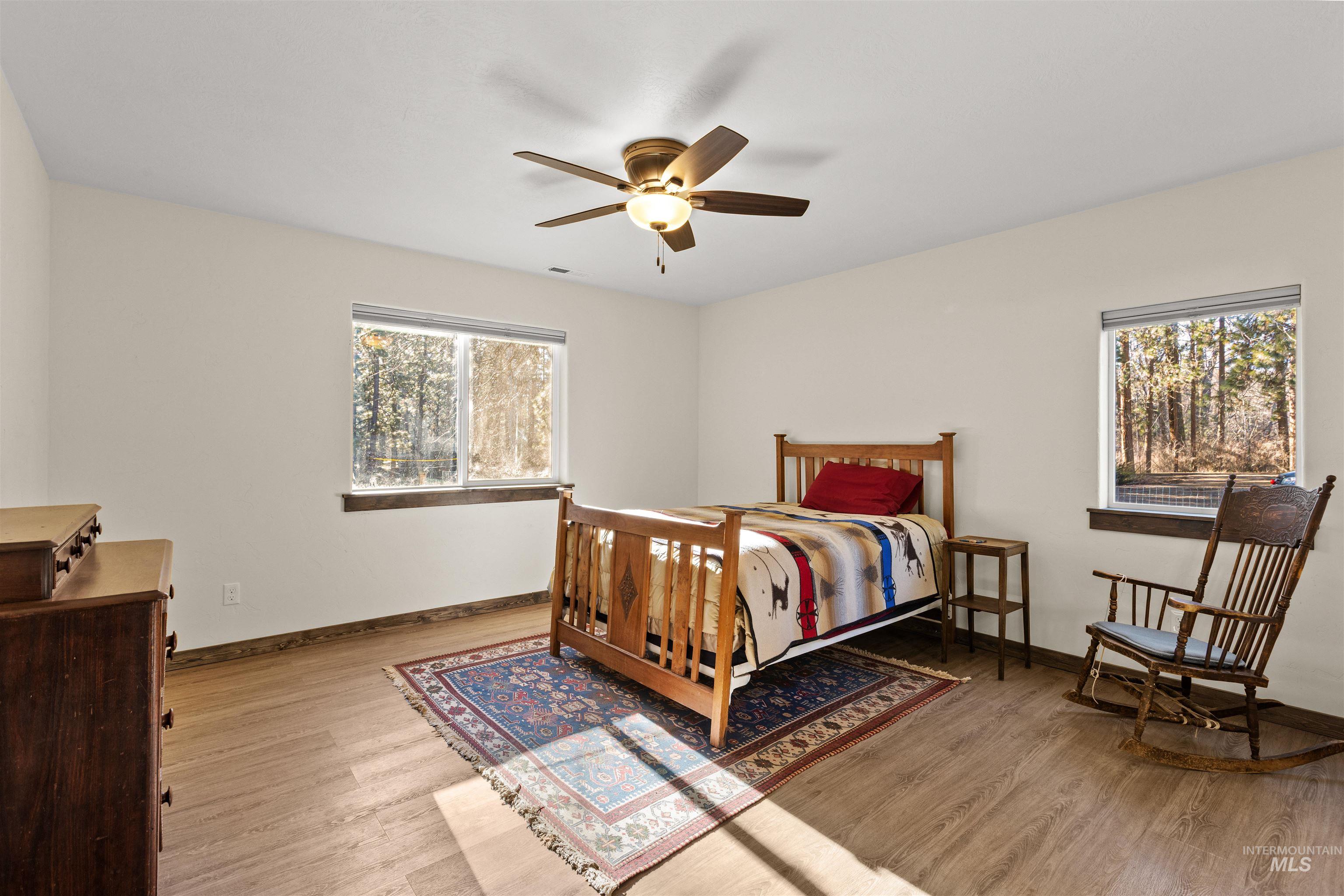 Bedroom with light wood finished floors and a ceiling fan