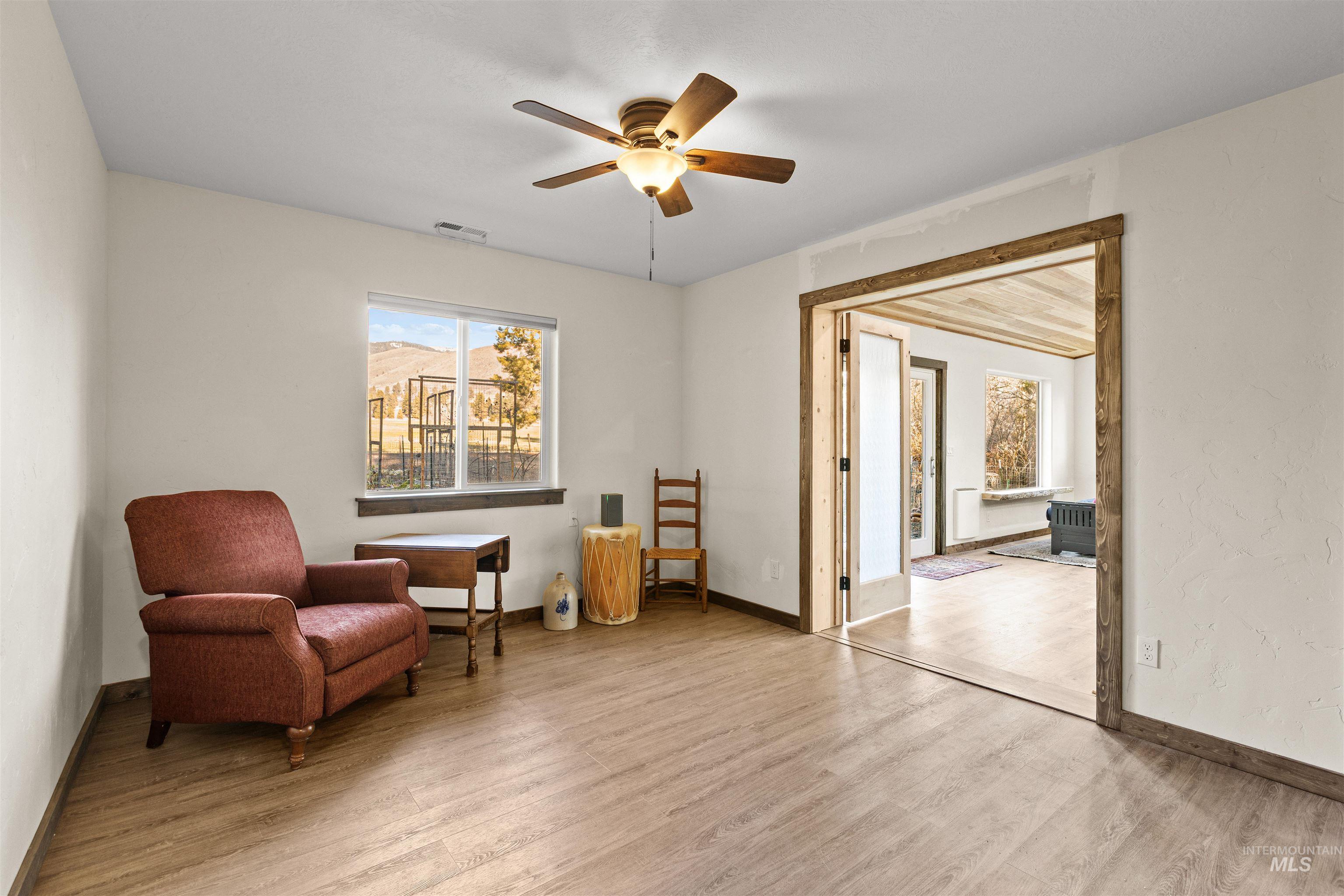 Living area featuring light wood-style flooring and ceiling fan