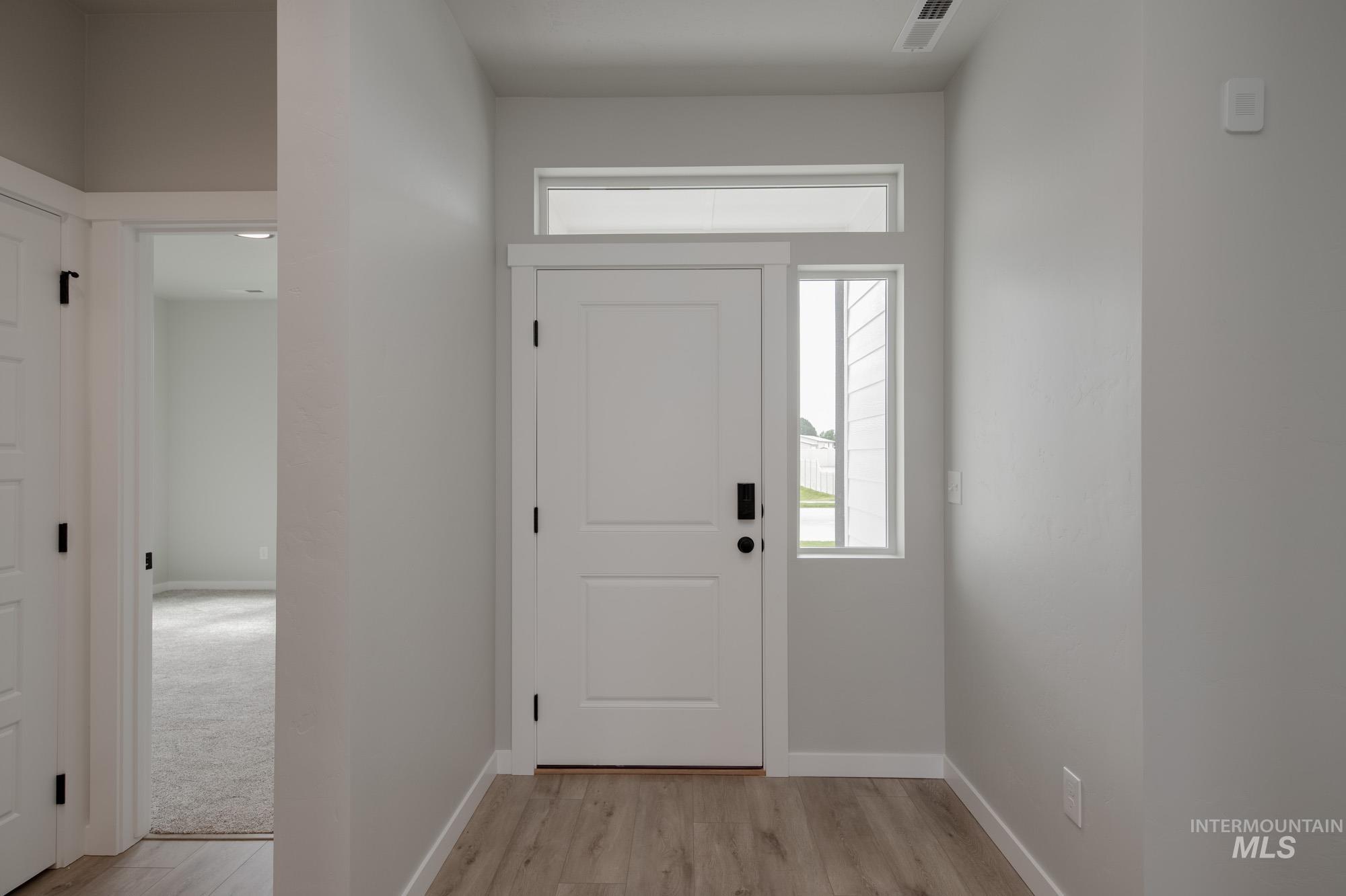 Foyer featuring baseboards and light wood-style floors