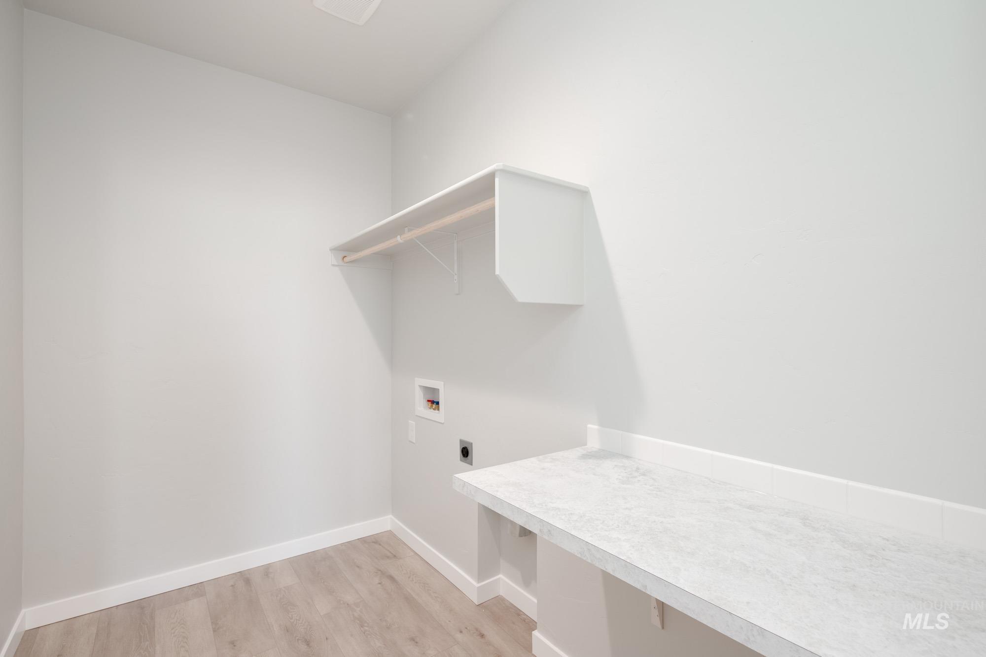 Laundry room with electric dryer hookup, light wood-style flooring, and washer hookup