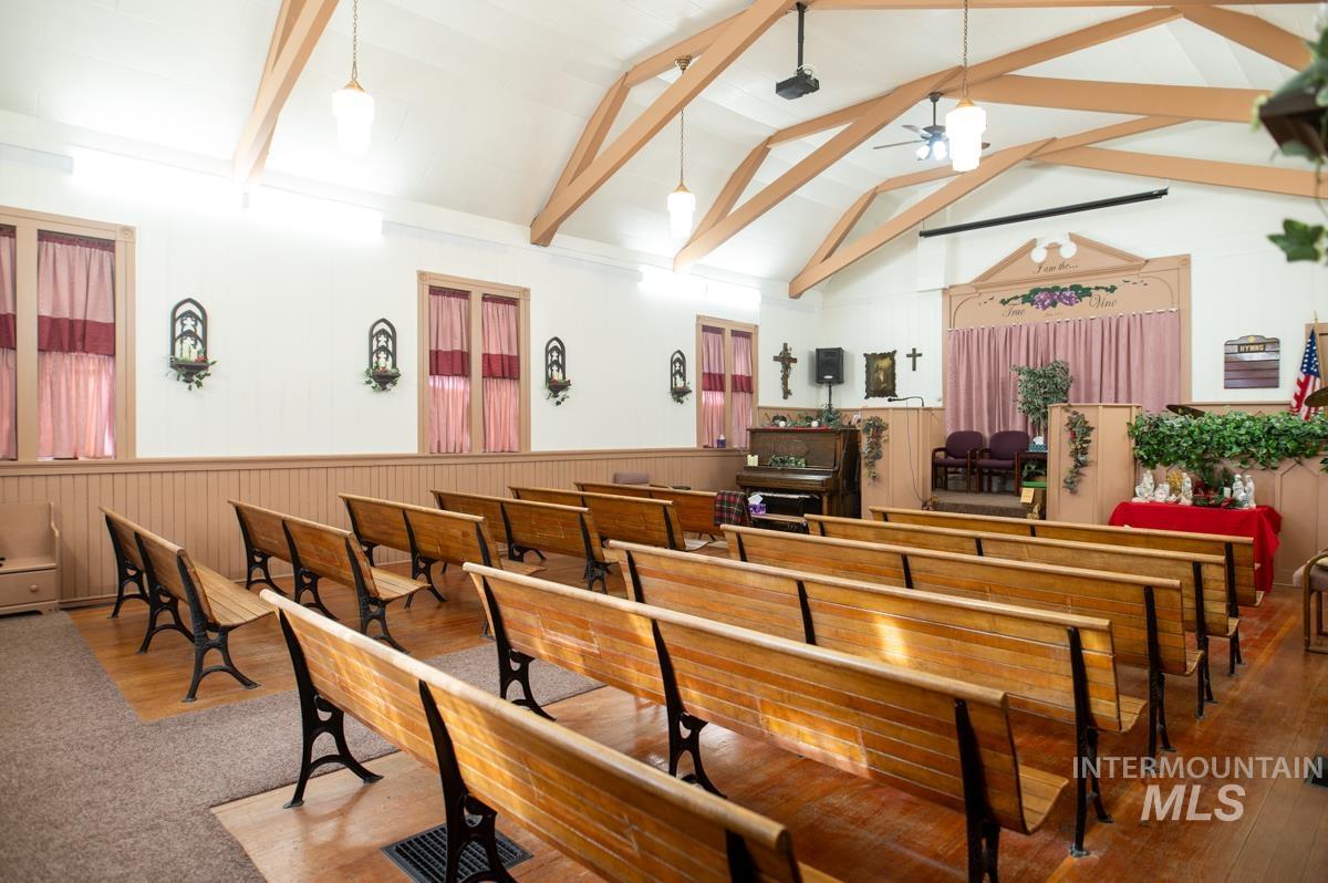 Misc room featuring a ceiling fan and a wainscoted wall