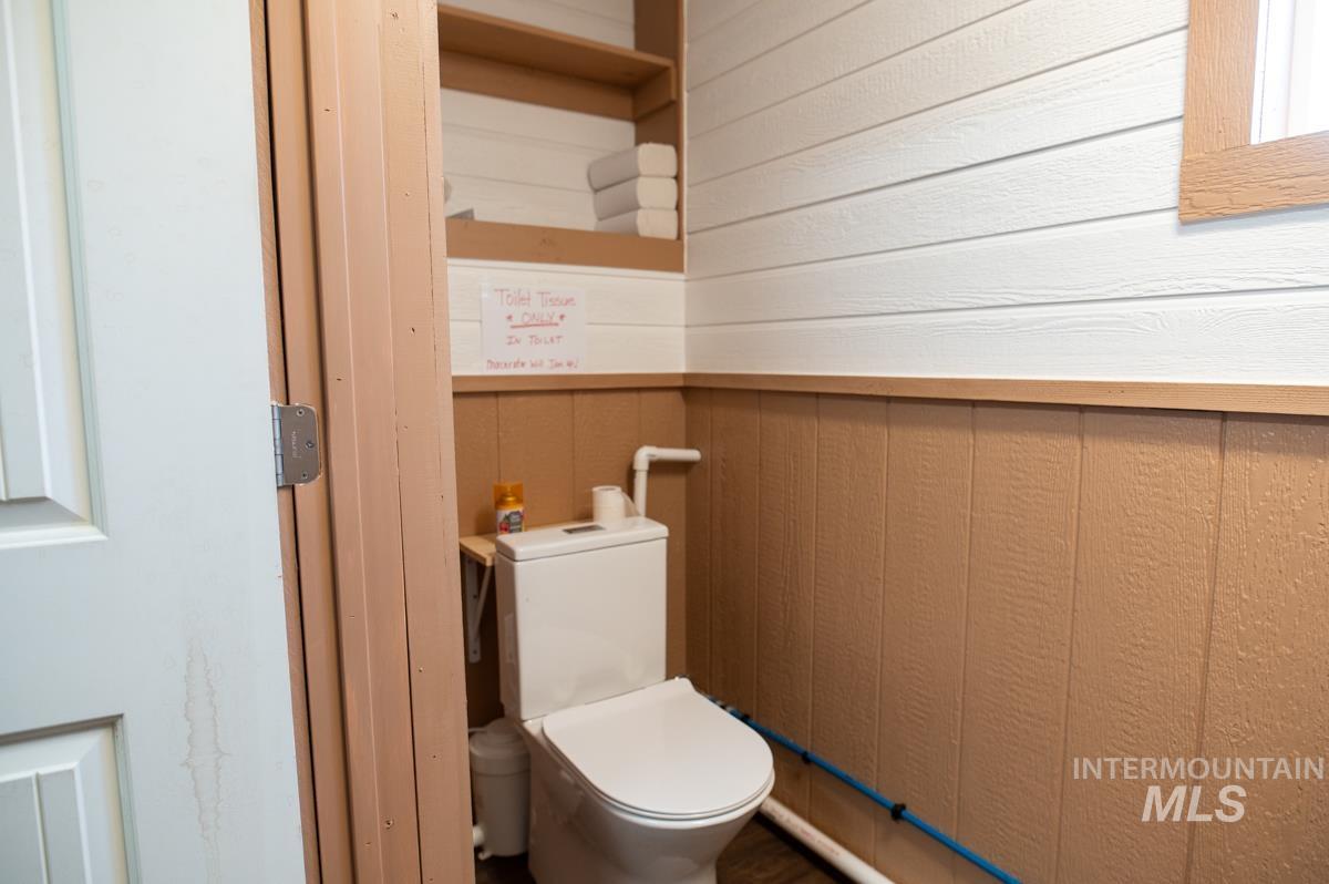 Bathroom with wood walls and toilet