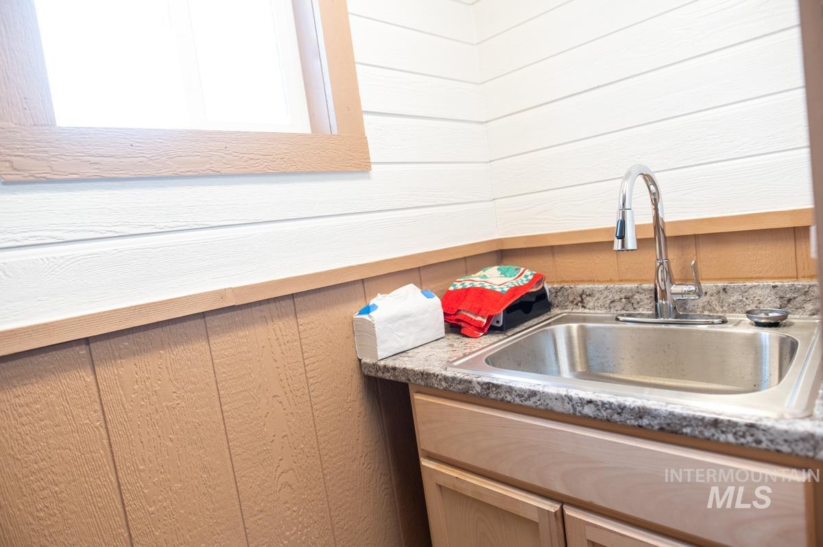 Kitchen featuring wood walls, light countertops, and light wood finish cabinetry