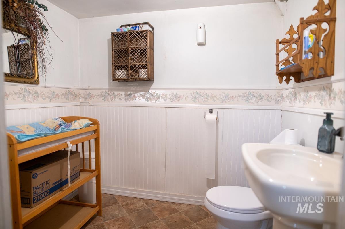 Bathroom featuring a wainscoted wall and toilet