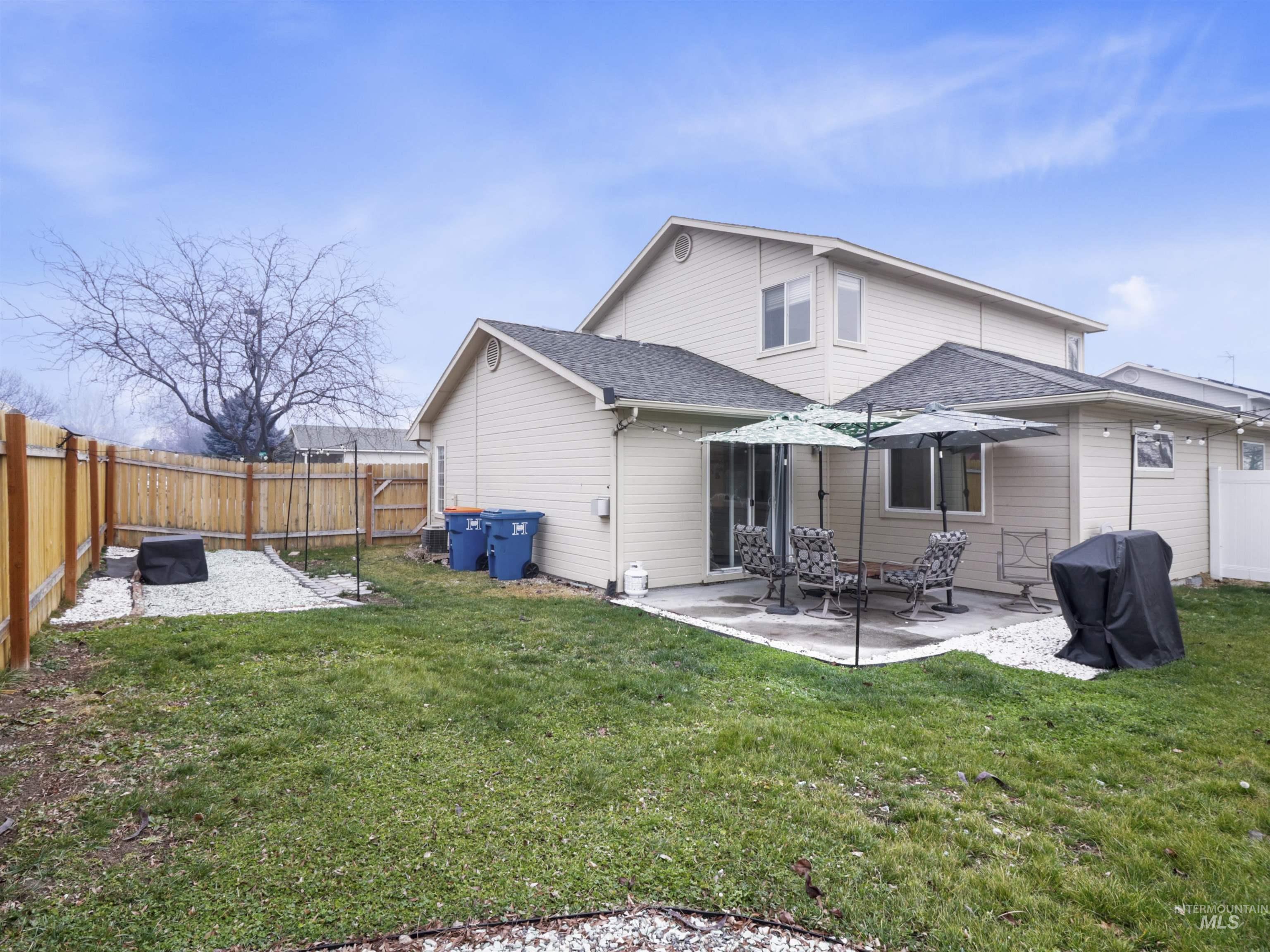 Rear view of property with a patio, a fenced backyard, and a shingled roof