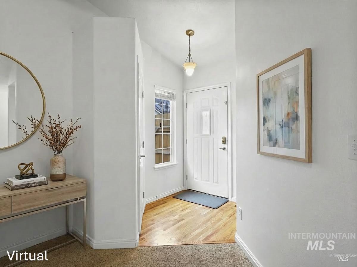 Entryway featuring light colored carpet and light wood-style flooring