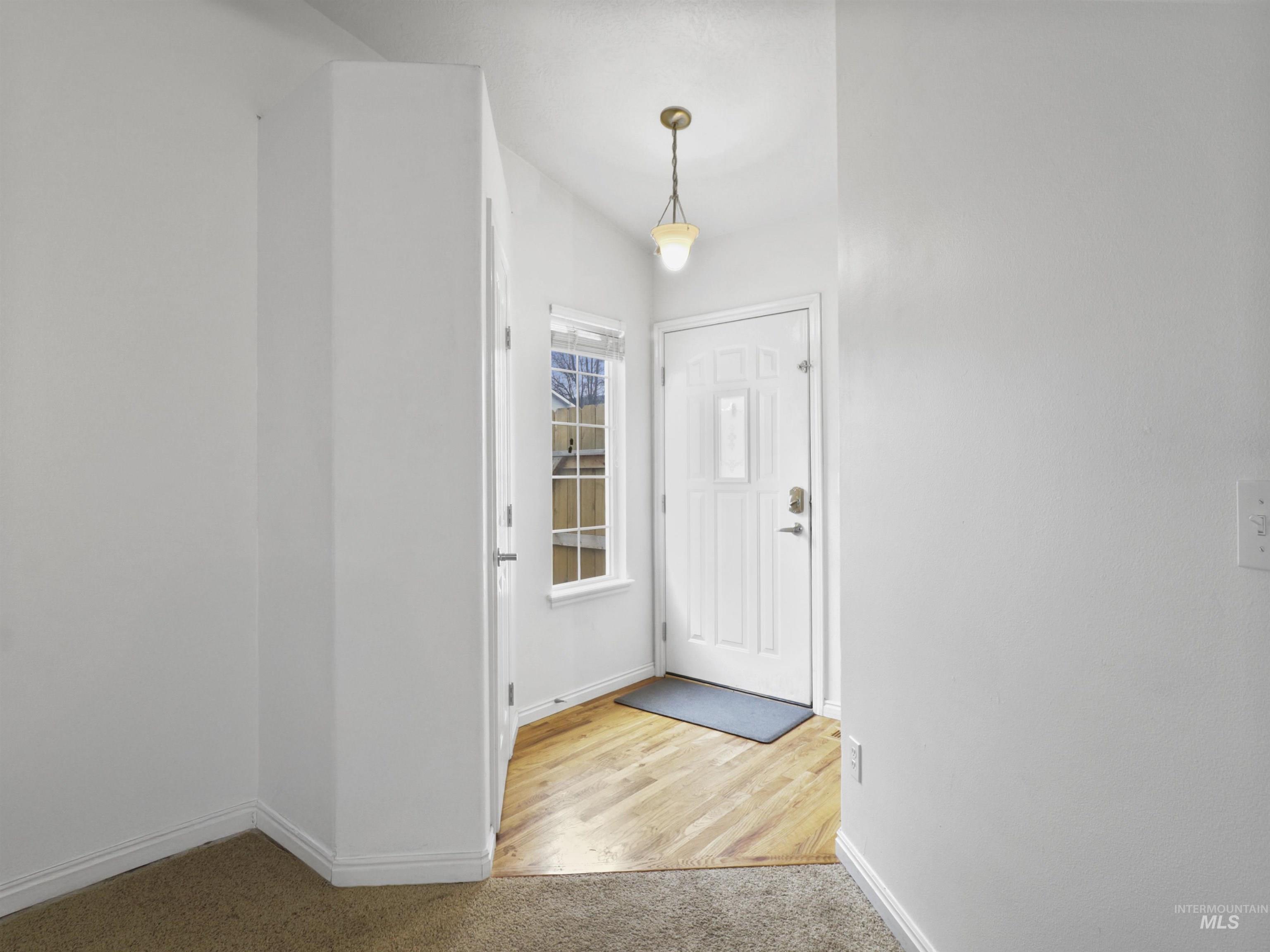 Entrance foyer with light carpet and baseboards