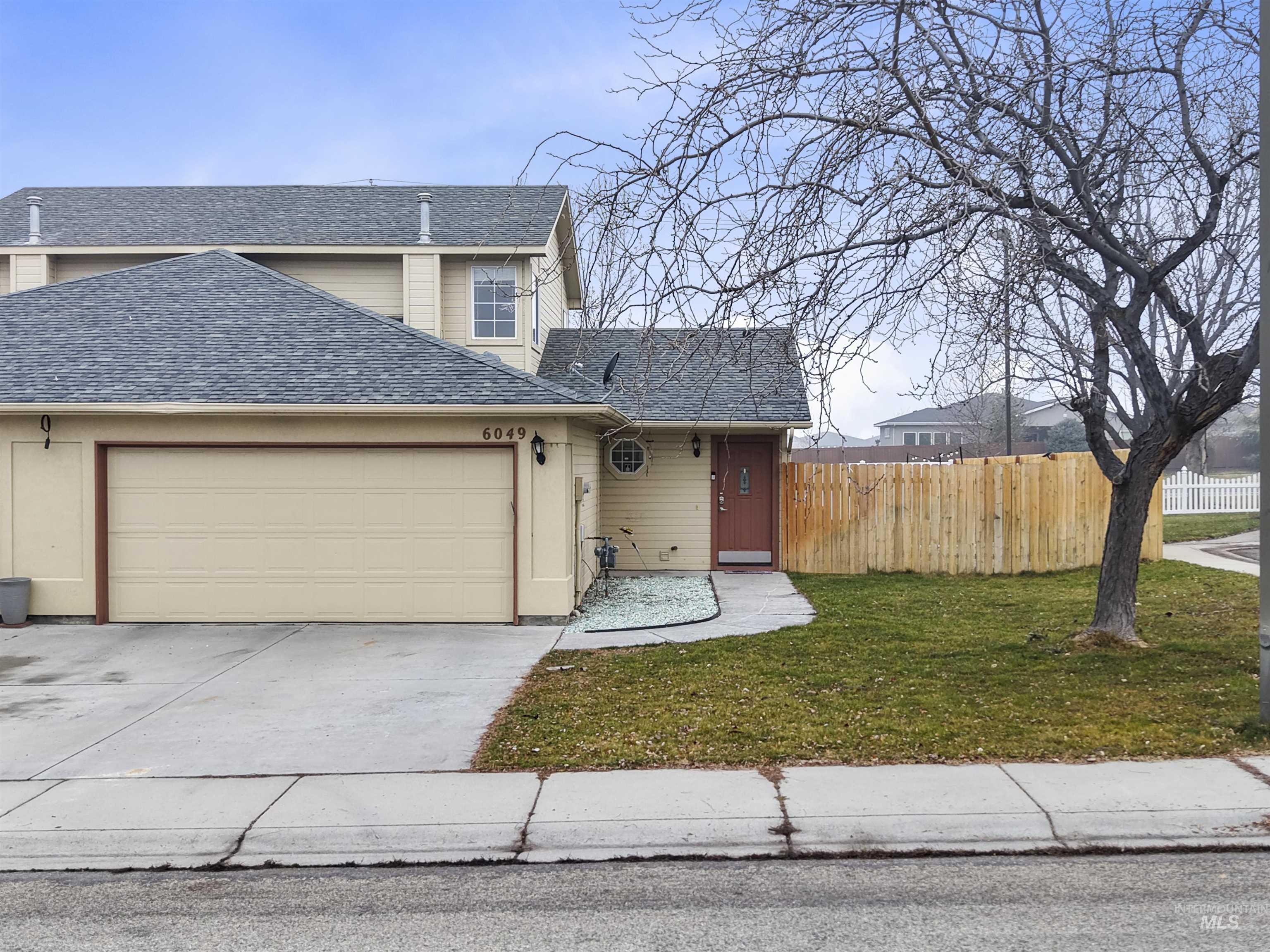 Traditional-style house with roof with shingles, driveway, and an attached garage