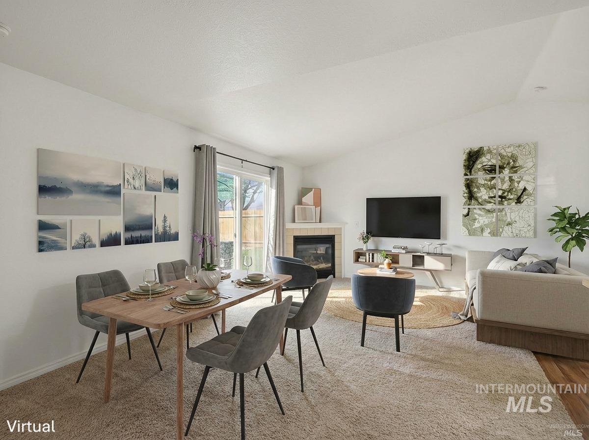 Dining space with a fireplace and lofted ceiling