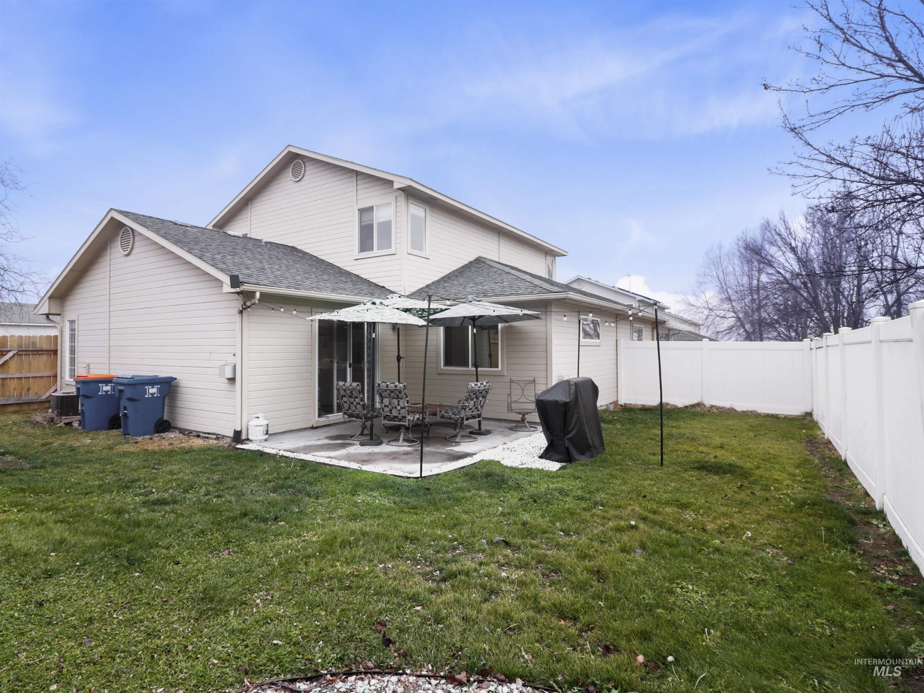 Back of house with a fenced backyard, a patio area, and a shingled roof