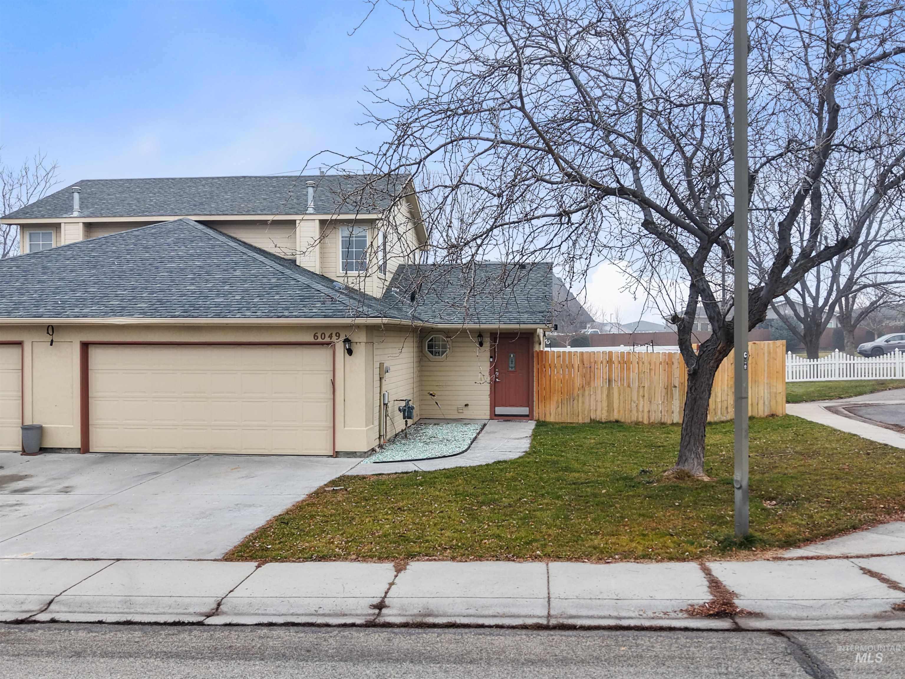 Traditional-style house with a shingled roof, concrete driveway, and a garage