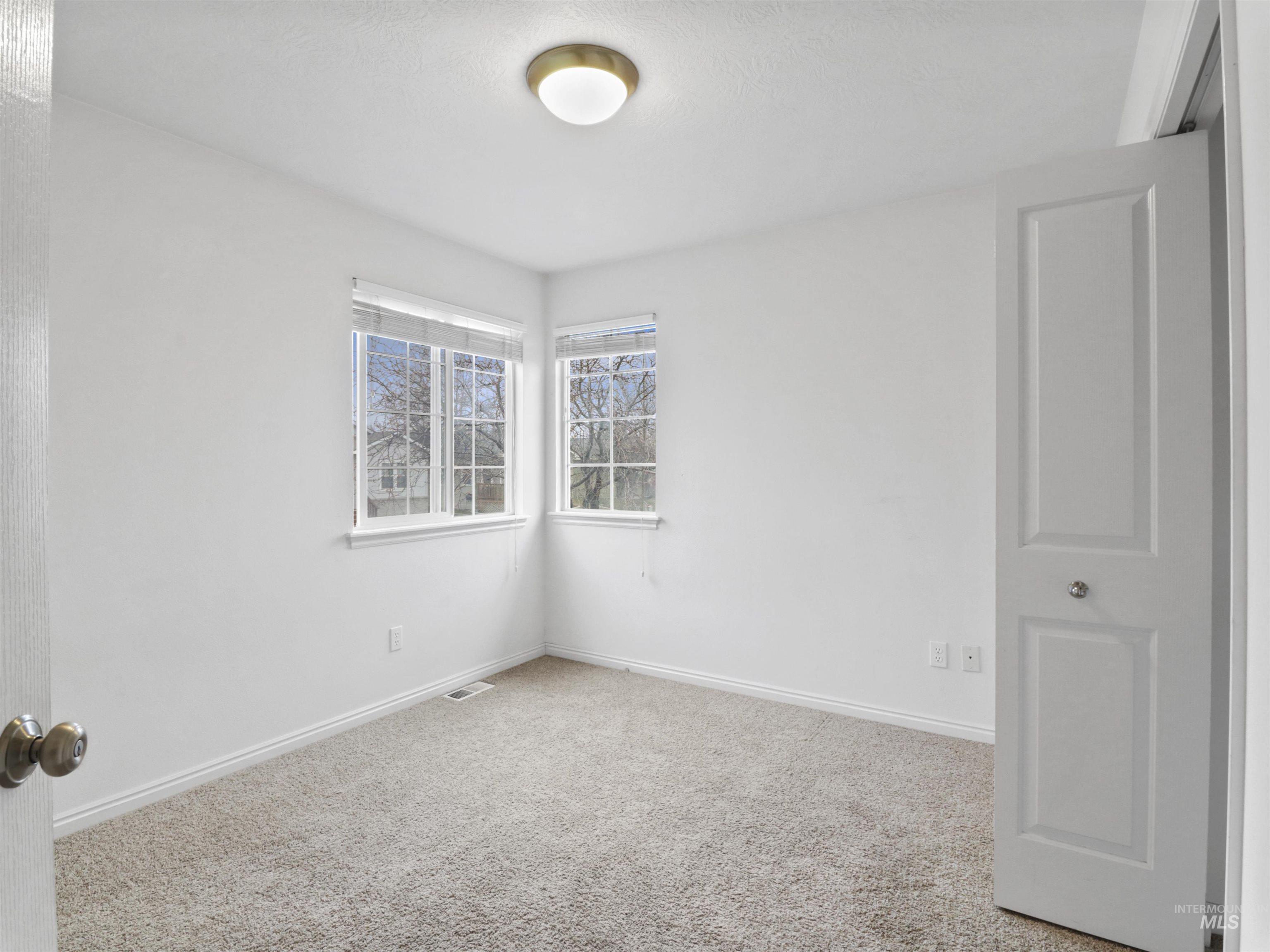 Empty room with carpet flooring and baseboards