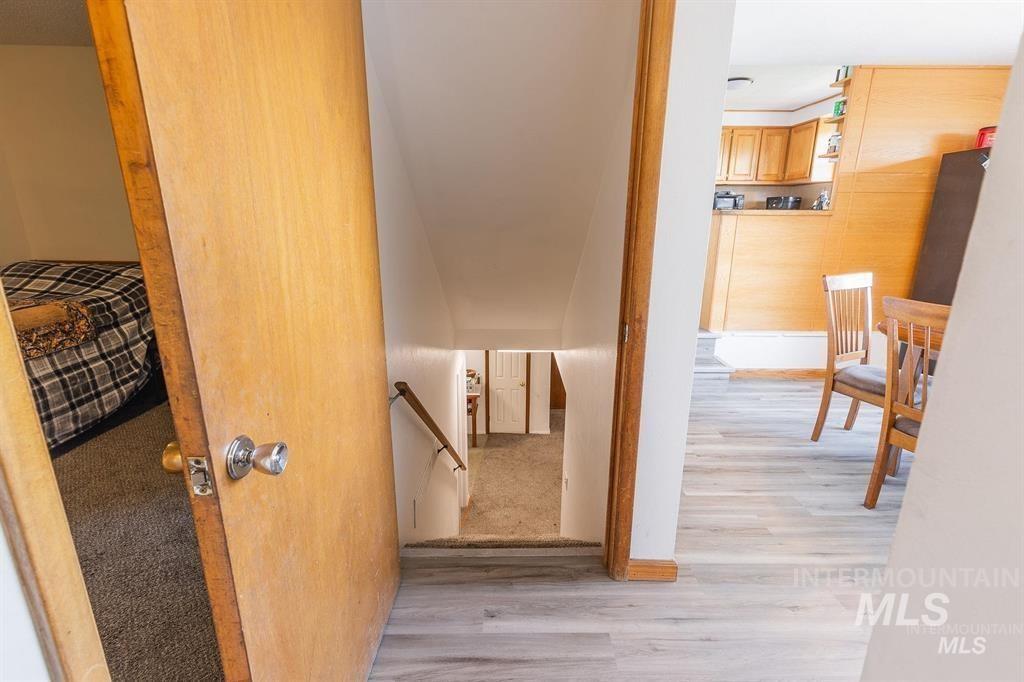 Hallway featuring light wood-style flooring and an upstairs landing