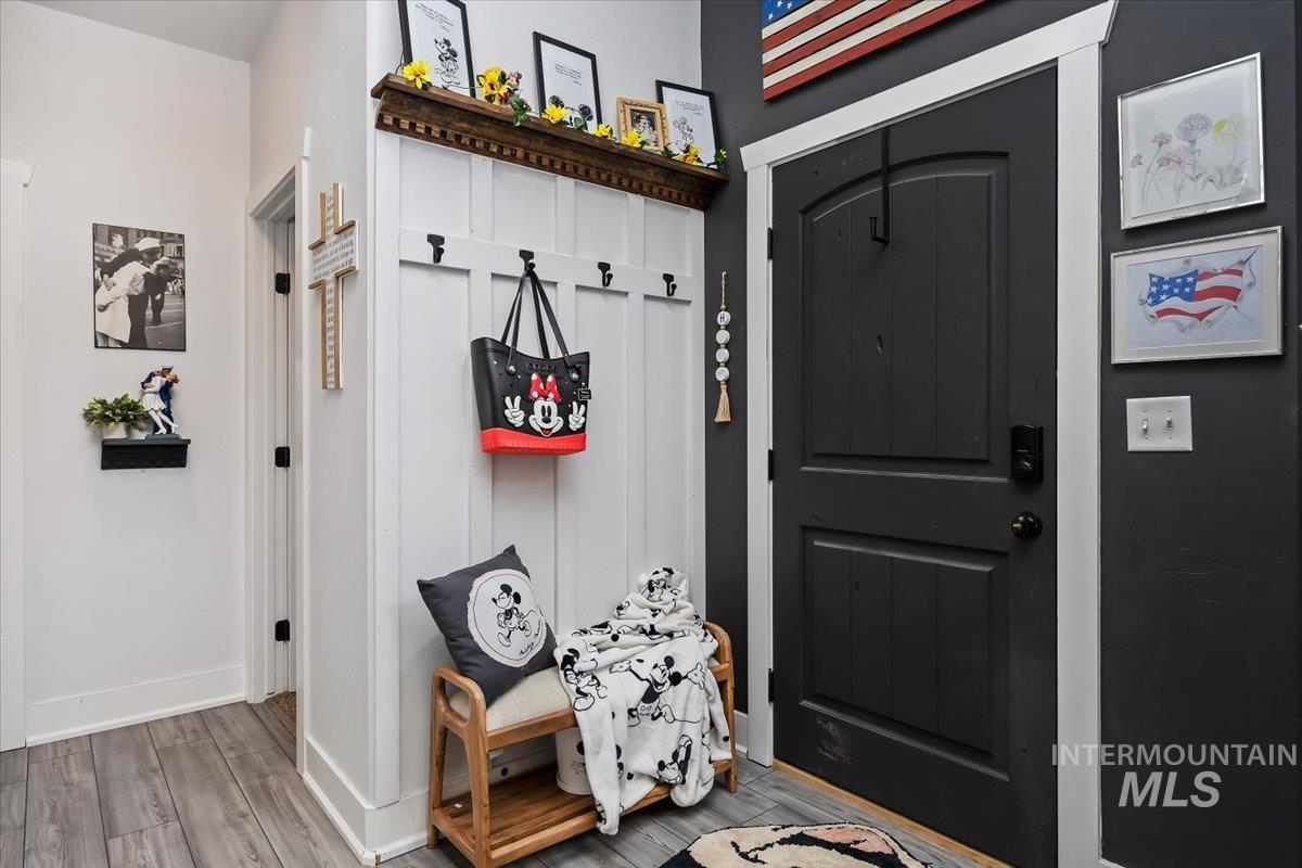 Mudroom with light wood-style flooring and baseboards