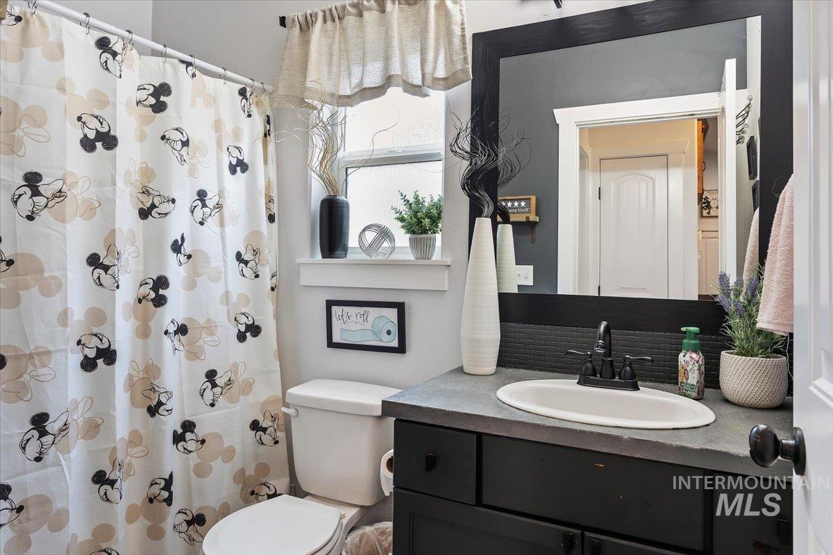 Bathroom with vanity, a shower with curtain, and decorative backsplash