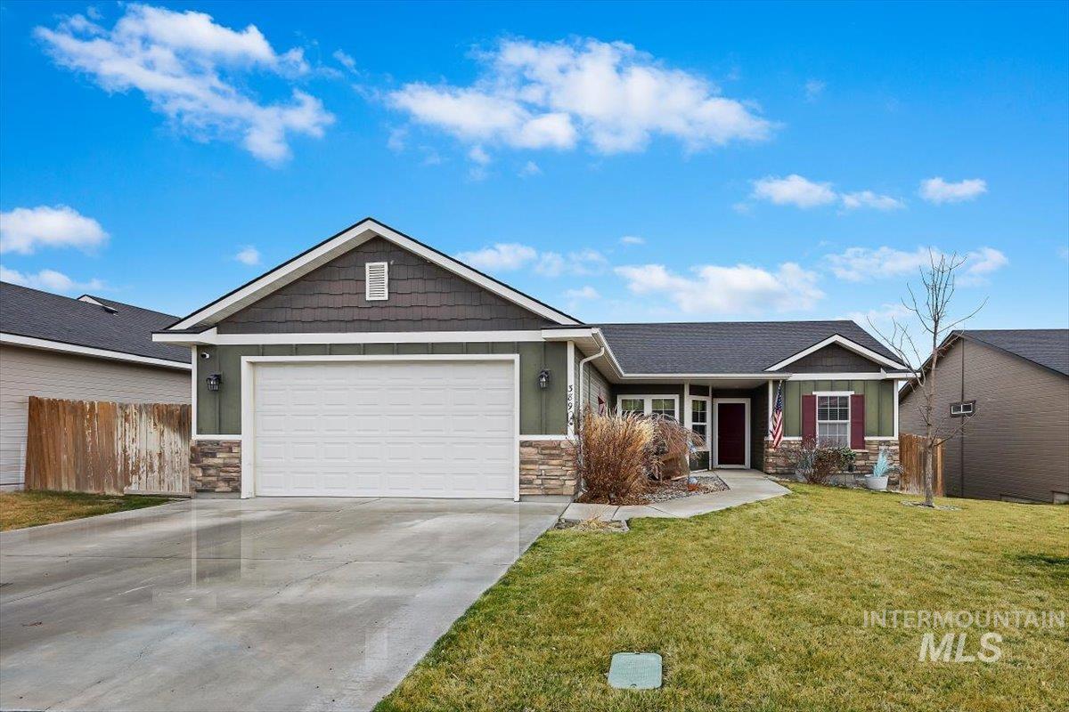 View of front of home with stone siding, concrete driveway, a garage, and board and batten siding