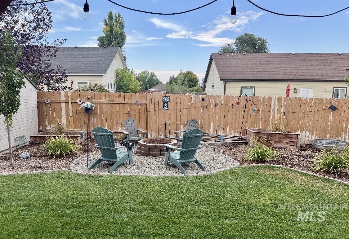 Fenced backyard with a patio and an outdoor fire pit