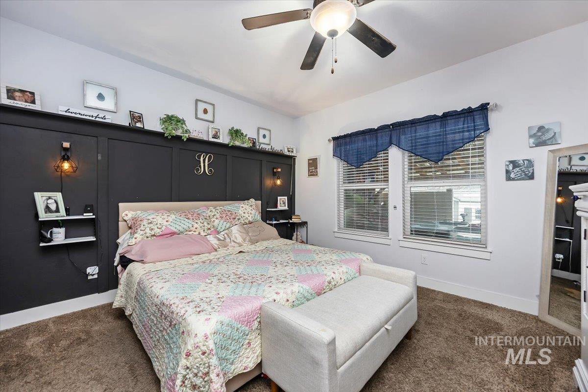 Bedroom with dark colored carpet and ceiling fan