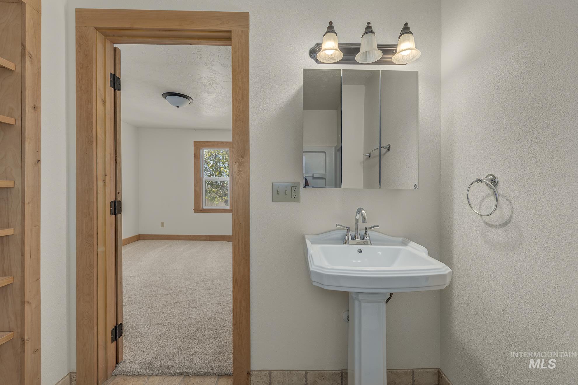Bathroom featuring light colored carpet and baseboards