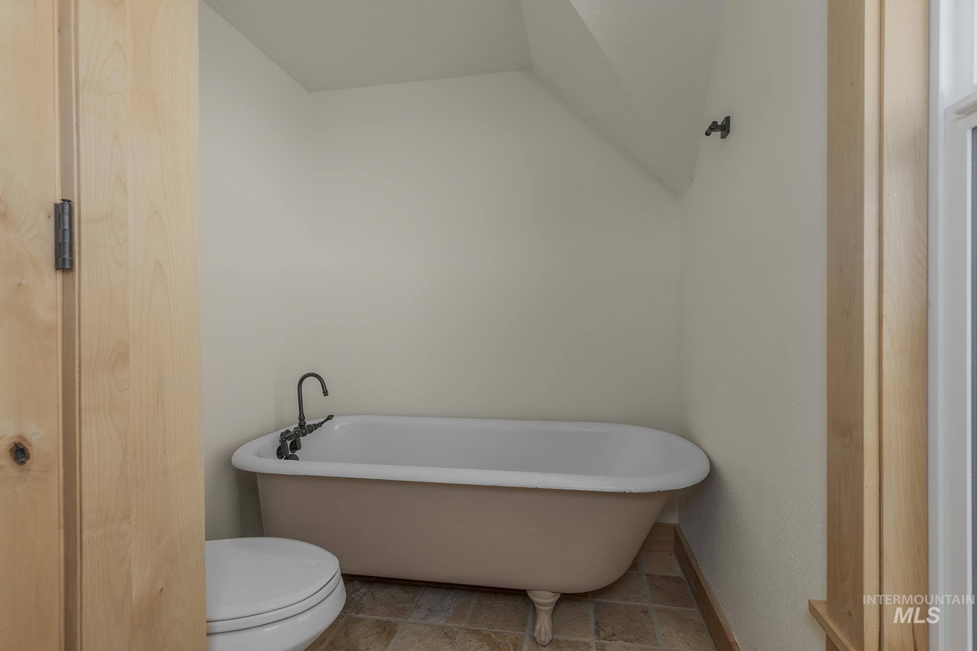 Bathroom with a soaking tub and toilet