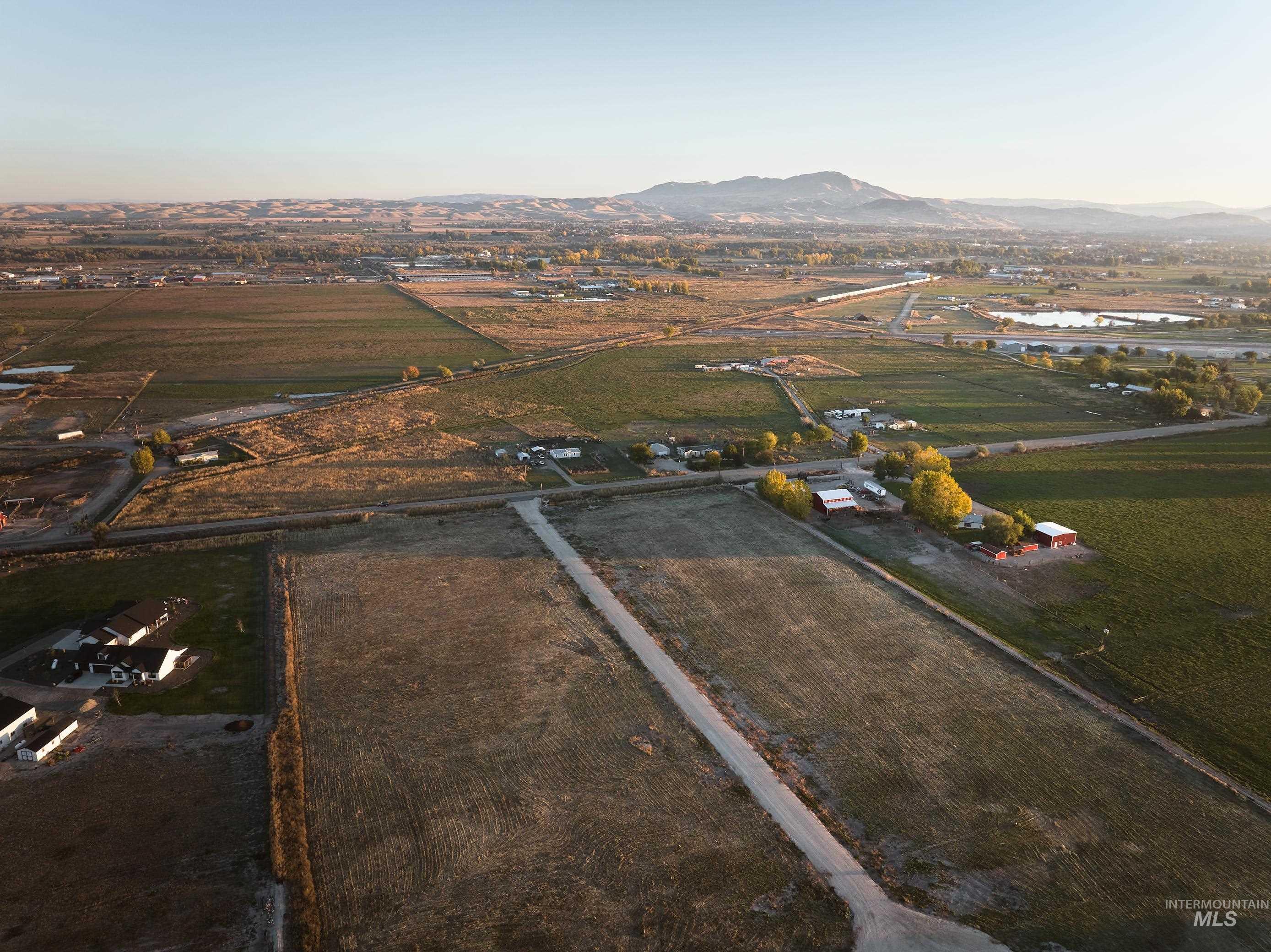 View of property location with rural landscape, rows of crops, and a water and mountain view