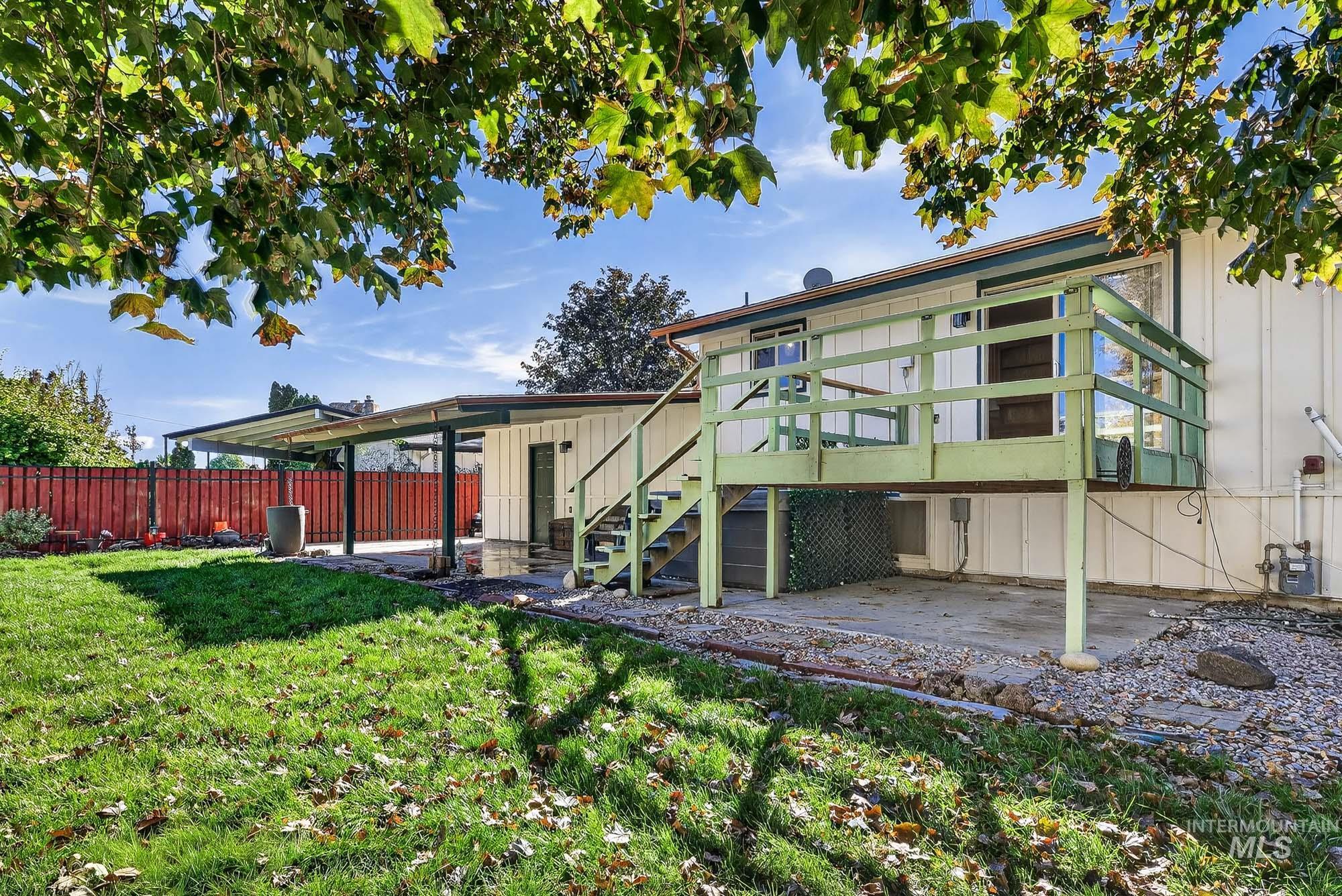 Rear view of house with stairway, a patio area, a deck, and board and batten siding