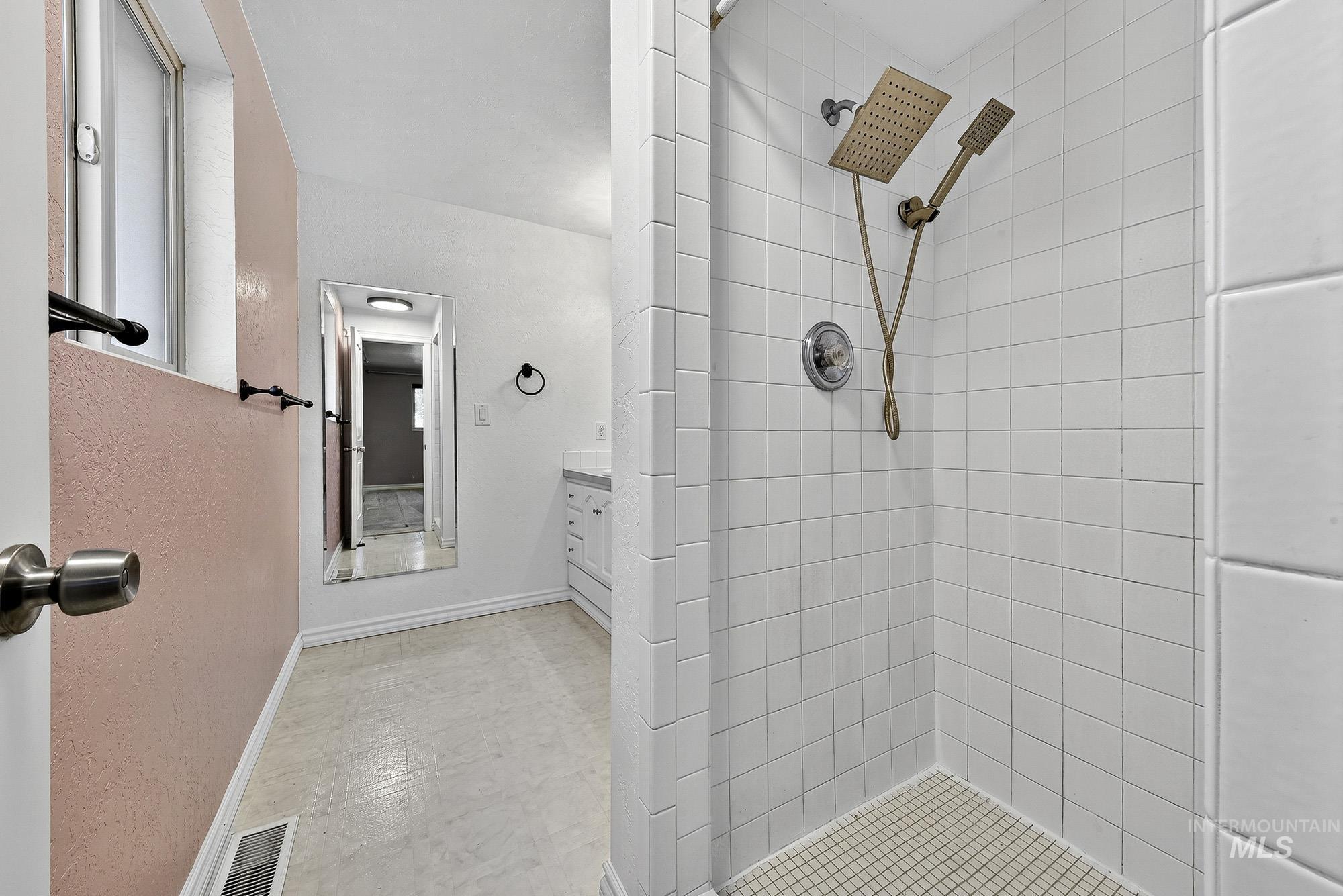 Bathroom featuring vanity and a shower stall