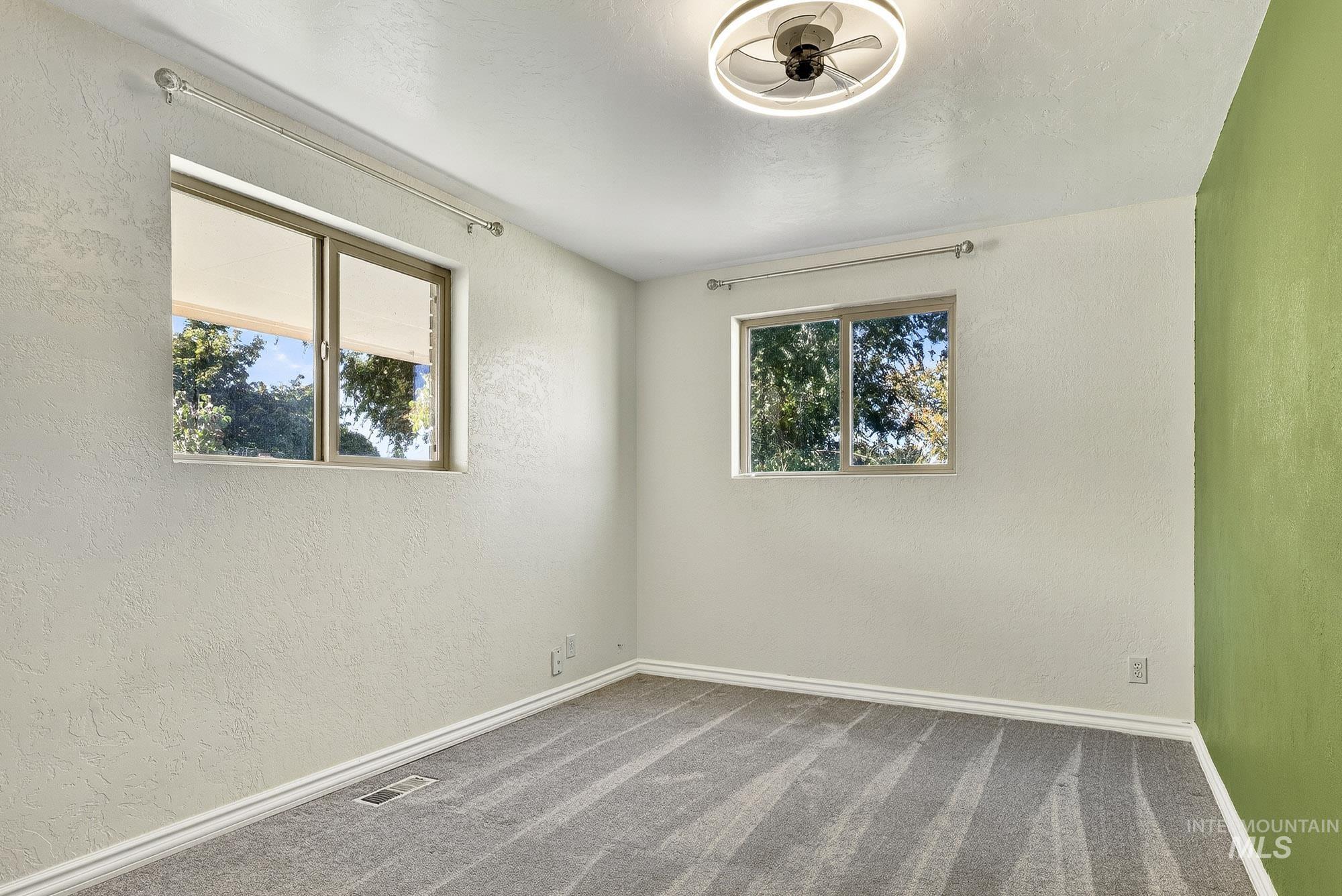 Carpeted empty room with a textured wall
