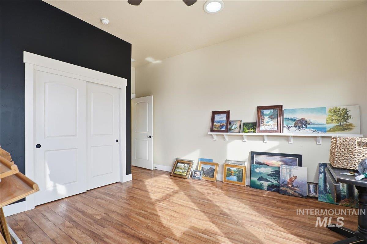 Home office with wood finished floors and a ceiling fan