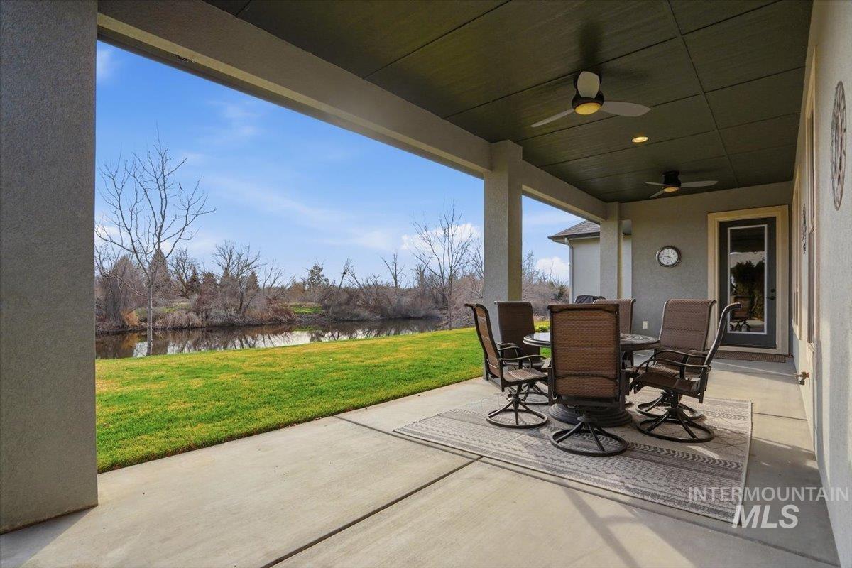 View of patio featuring outdoor dining space, a ceiling fan, and a water view